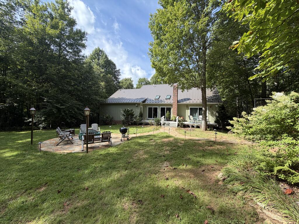 Private 39.17 Acre Retreat with Dan River Frontage in Patrick County Enjoy the privacy and natural beauty of this exceptional 39.17 acre property in Patrick County, Virginia. Tucked away behind a locked gate entrance, this contemporary-style home is surrounded by mature woods, abundant wildlife, trails, and the peaceful sounds of nature. The home is ideally positioned in the center of the property, creating a truly private retreat while offering direct access to the property's natural amenities. The residence offers approximately 3,168 square feet of finished living space, plus approximately 864 square feet of semi-finished basement space. The main level features a spacious open-concept kitchen, dining area, and living room, creating a comfortable setting for everyday living and entertaining. Also on the main level are two bedrooms, a library, full bath, laundry room, and a private primary bedroom with en-suite bath. The full basement provides additional flexible space, including a workshop, with ample room for storage, hobbies, projects, or future finishing. Heating and cooling are provided by a propane furnace with central air, and the home features an on-demand propane water heater. Enjoy the outdoors from the front porch, back deck, and patio, each offering a place to relax and take in the surrounding landscape. The property also includes underground electric and telephone service, a storage building, and Starlink is currently used by the sellers. Most of the furnishings will convey with the home, making this a move-in-ready opportunity. Simply bring your personal belongings and begin enjoying this private Virginia retreat. The land is the true highlight of this property. Approximately 1.5 acres are open around the home, while the remainder is wooded, providing privacy, natural beauty, and excellent recreational opportunities. The property features frontage along the Dan River, as well as two spring-fed creeks.