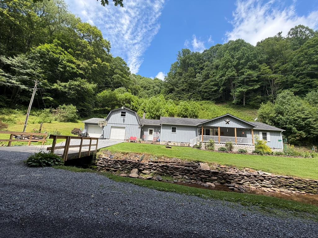 Beautiful home in a tranquil setting nestled in the heart of Green Cove, Virginia.  Come relax and unwind as the peaceful sounds of the creek carry your worries away. Situated on 5.22 acres, this property offers easy access to the Virginia Creeper Trail just minutes away and is surrounded by the beauty of nature with abundant wildlife. Conveniently located near the Appalachian Trail and Grayson Highlands State Park, this property is ideal for outdoor enthusiasts and those seeking a peaceful mountain retreat.  The home features three spacious bedrooms, two large bathrooms, and an oversized mudroom/laundry area designed for everyday convenience. Enjoy abundant storage space along with two garages, offering plenty of room for vehicles, hobbies, and outdoor gear.  Whether you are looking for a full-time residence, weekend getaway, or investment opportunity as an Airbnb, this property offers the perfect blend of comfort, recreation, and natural beauty