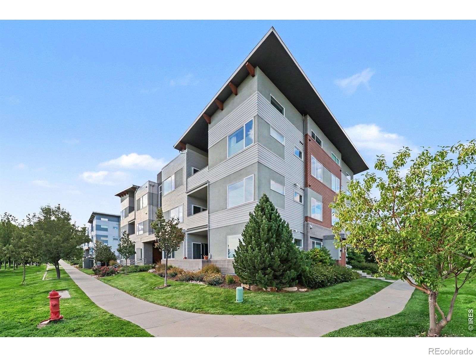 This is a coveted top-floor corner unit with fabulous views in a secure and very quiet building, with an elevator. It is totally walkable to 2 lakes, hiking and biking trails, + shopping, and more. Both bedrooms have high ceilings with clerestory windows and 7' doors, and has no one above it. This unique condo is the only one in the complex with solid wood floors in the living areas. The seller loved to cook and upgraded the kitchen appliances recently with stainless steel and an induction range. Maple Shaker cabinetry provides copious kitchen storage with tasteful quartz surfaces including a breakfast bar. The southern exposure provides plenty of light and has great views of the foothills. The primary bedroom is an en-suite with double vanities, and the laundry is in-unit. Pets are welcome! Anyone with bikes, skis and lots of other stuff, will love that this includes the largest garage in the complex so you don't have to keep it in your living room like Seinfeld did.