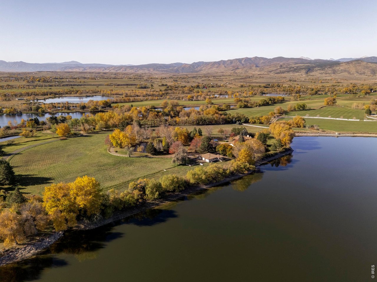 Seize a truly exceptional opportunity to own one of the most significant waterfront compounds in Colorado's Front Range. Spanning nearly 50 combined acres of pristine Boulder County landscape, this legacy estate consists of four distinct parcels anchored by a massive 16.6-acre, spring-fed private lake and the invaluable ownership of 1.375 shares of the Palmerton Ditch. Offering a level of recreational freedom and private water access that is nearly impossible to replicate, the North Lake House Lot at 0 Rozena Drive encompasses the entire private lake, and includes a designated buildable envelope for a 6,500-square-foot residence positioned directly at the shoreline with unobstructed views of Longs Peak. The lake has produced trophy catches including 27" bass and 17" crappie, sitting alongside a pond fed by the Longmont Supply Ditch. Whether enjoying a paddle board session or navigating the picturesque path encircling the water, the estate offers a profound connection to a thriving ecosystem. Beyond the shoreline, the residential offerings are equally remarkable, beginning with a stately gated entrance and winding drive. The primary residence is a masterpiece of light and glass, featuring a sun-drenched atrium and stone fireplaces. Outdoor living is defined by a pool, terraced balconies, and pool house set against the backdrop of Burch Lake and fruit orchards. Complementing the home is a multifunctional barn with an office, kitchen, and equestrian stalls. An adjacent parcel, currently a hay farm, offers flexibility to expand with an allowable 5,500-square-foot residence site. The footprint is completed with the fourth parcel, protected by an agricultural conservation easement, ensuring permanent privacy. With Palmerton Ditch shares providing an abundant water supply, the land remains productive and beautiful. This is a rare intersection of pastoral seclusion and world-class luxury, offering the singular privilege of a life where the horizon is yours alone.
