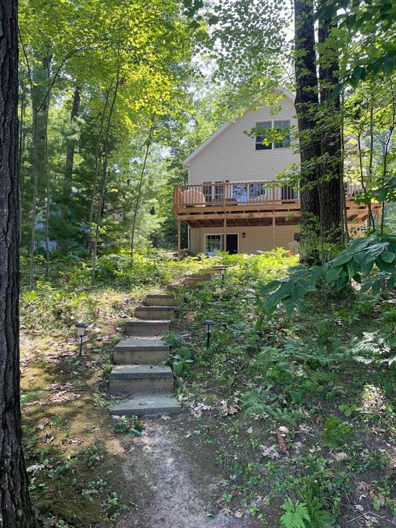 Wake up to breathtaking waterfront views in this stunning, fully updated home on beautiful ALL SPORTS Perch Lake. With 5 bedrooms ~ 3 full baths and over 2,500 sq ft of living space this spacious retreat offers the perfect blend of cozy cottage and lakeside charm. Step inside to an inviting open-concept main level featuring rich wood floors, maple cabinetry, solid surface countertops, and a large center island-ideal for gathering with family and friends. The dining and living areas flow seamlessly together, highlighted by a cozy wood stove and a dramatic wall of windows with double sliding doors that frame spectacular lake views and fill the home with natural light. Step out onto the oversized deck to enjoy the up north wooded atmosphere, relax, entertain, and enjoy peaceful mornings or sunset evenings overlooking the lake and private beach. Upstairs, you'll find two large bedrooms and a full bath, including a serene primary-style retreat with a custom white shiplap vaulted ceiling, walk in closet and picturesque lake views-your own private escape. The newly finished walkout lower level expands your living space with a generous family room, a charming nook tucked under the stairs, two additional large bedrooms, and a full bath-perfect for guests, a home office, or multi-generational living. The lower level  has a walk out basement with sliding glass door that leads to the brick patio under the first floor deck. Outside and to the front, there is a spacious 30'x 40' pole barn for all your toys! Built in 2017, it has concrete flooring, 3 garage access doors and 100 amp electrical service. On the lakeside, you have 70' of frontage with a large sandy beach, an 8'x8' shed and a new platform dock to tie your 'toon up to or simply cast your fishing line! One last bonus, this home has natural gas and central air! Whether you're looking for a year-round residence, rental investment or the ultimate lakefront getaway, the exceptional Perch Lake property offers space, style, and stunning views in every season. Schedule your