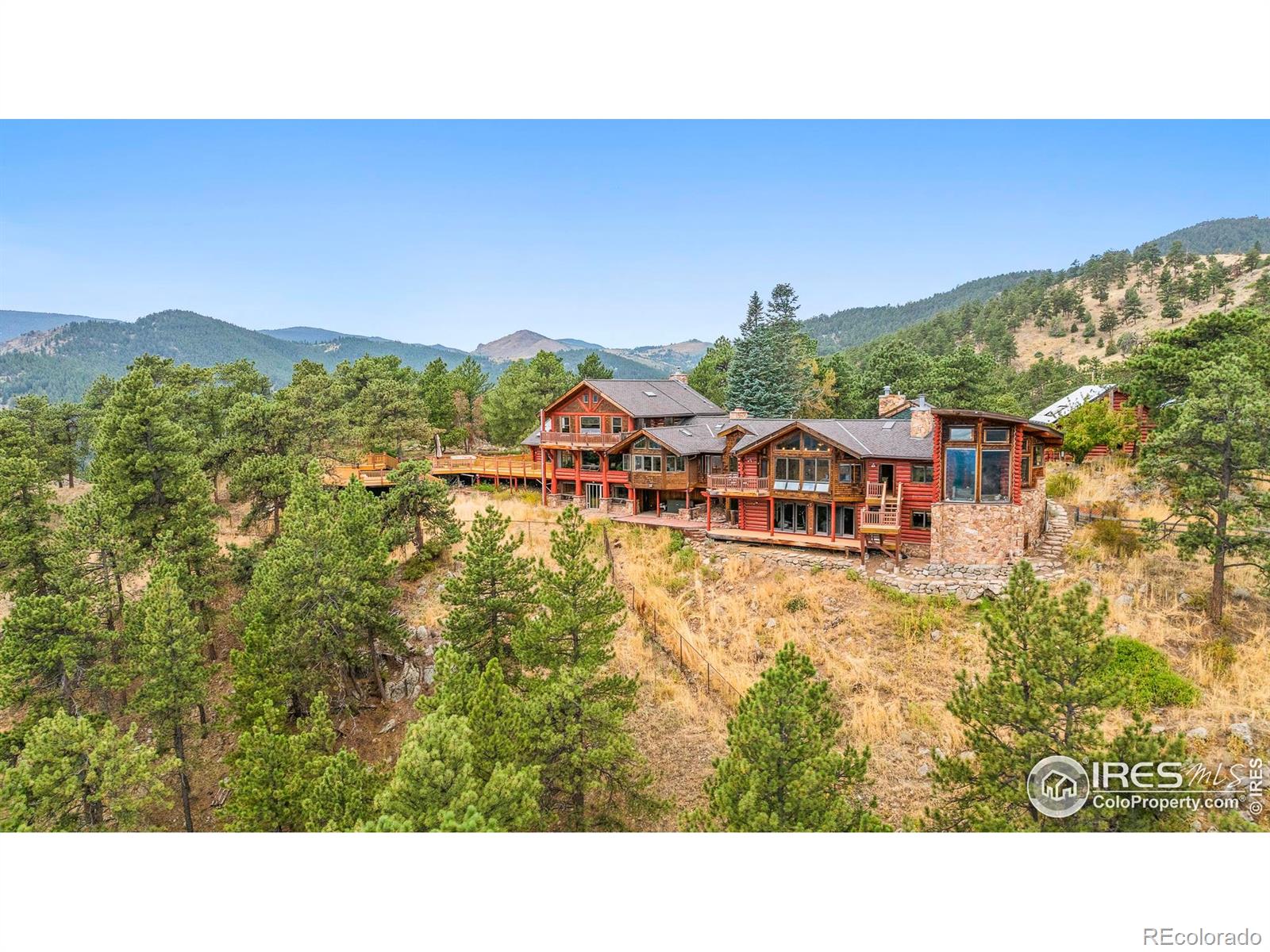 Welcome to Palacio Celestial: A 230-acre legacy estate of pristine mountain property, bordering the Betasso Preserve. This rare offering combines unrivaled privacy, serenity, and panoramic views, all just 10 minutes from downtown Boulder and 20 minutes to Eldora Mountain Ski Resort. The estate encompasses five parcels, each over 38 acres, offering breathtaking vistas. Two parcels with dwellings: the impressive 8,600-square-foot main residence and a beautifully remodeled three-bedroom guest home. A gated, winding drive leads to the iconic log-style main house, where a water feature sets the stage for sweeping views of the Front Range, snow-capped peaks, and city lights. Designed for entertaining, the residence offers multiple living and gathering spaces, including a grand living and dining room with dramatic windows, a walk-out level with a speakeasy, gym, and game room, plus a luxurious main-floor primary suite. This sanctuary features walls of glass, a two-sided fireplace, and a spa-inspired grotto bath with waterfalls, steam shower, jetted tub, and cold plunge. Expansive outdoor living includes a wraparound porch, sparkling 44' swimming pool, and endless views. Property features include solar panels, two generators, a fire suppression system, and a detached 3-car garage with office and loft storage. The second residence, a charming log home with a wraparound deck, is paired with a stylish guest suite above a two-car garage. Both homes adjoin a 40-acre conservation easement, ensuring protected privacy with no neighbors within half a mile. Palacio Celestial is more than a home-it's a private mountain retreat and legacy estate, blending timeless log architecture, modern comforts, and Colorado's most captivating landscapes