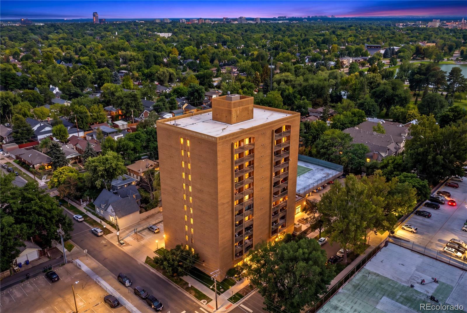 Perched above one of Denver’s most beloved neighborhoods, this exceptional 12th-floor penthouse puts you just steps from the shimmering lake and open lawns of Wash Park, with panoramic mountain views as your backdrop! This beautifully updated 2-bedroom, 2-bath condo offers the perfect blend of city convenience and peaceful residential living!  Secure ButterflyMX access welcomes you into the building, where the elevator whisks you to the top floor!  Inside, the lovely kitchen features oak cabinetry, quality appliances and an open pass-through to the dining and living areas, perfect for everyday living and entertaining!  Rich Carlisle wide-plank real pine flooring flows into the inviting living room, where floor-to-ceiling windows fill the space with natural light and frame spectacular mountain views! A custom Hunter Douglas solar shade adds energy efficiency and comfort, while the covered west-facing balcony is the perfect place to relax and take in Colorado sunsets!  Both bedrooms are generously sized, the walk in shower has Jerusalem tile!  The primary suite features a private 3/4 bath and sliding glass doors opening directly to the balcony, while the second bedroom enjoys a full bath just steps away! Both baths offer classic tilework and oversized vanities with abundant counter space and storage!  Building amenities include an indoor lap pool, cedar sauna, community hot tub, tennis courts, covered assigned carport, secured storage, on-site laundry, worry-free unit maintenance, video surveillance and EV charging! The location is truly hard to beat! Walk to Starbucks, Blackbird Public House, Restaurant Olivia and Origins Sports Bar & Grill! Bike to Old South Gaylord or Cherry Creek for shopping and dining! Enjoy Bonnie Brae Ice Cream less than a mile away! Only 1/2 block to Wash Park’s beautiful lakes, gardens and walking paths, as well as the Wash Park Rec Center. Steele Elementary School and South High! Easy access to 6th Avenue and I-25! OPEN HOUSE SATURDAY!!