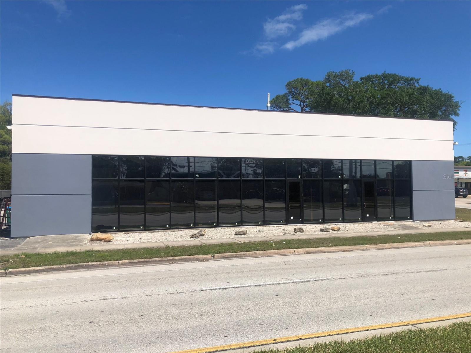 Under contract-accepting backup offers. Update: Seller Financing may be available.  Large clear-span building with 6400 sq ft on main floor, plus 3000 sq ft mezzanine/equipment platforms, on 164 ft of US1 / Ridgewood Ave frontage, with 22 parking spaces.  Zoned B4 in Holly Hill allows many different uses.  Beautiful new 2023 storefront with low-e, bronze, large missile hurricane triple pane glass.  Interior is ready to customize for your needs.  5 bathrooms, two power meters. Floor plan can be split (previously retail furniture and retail plumbing).  12'x12' hurricane door (2018) to high-bay in back.  Roof recoated 2023