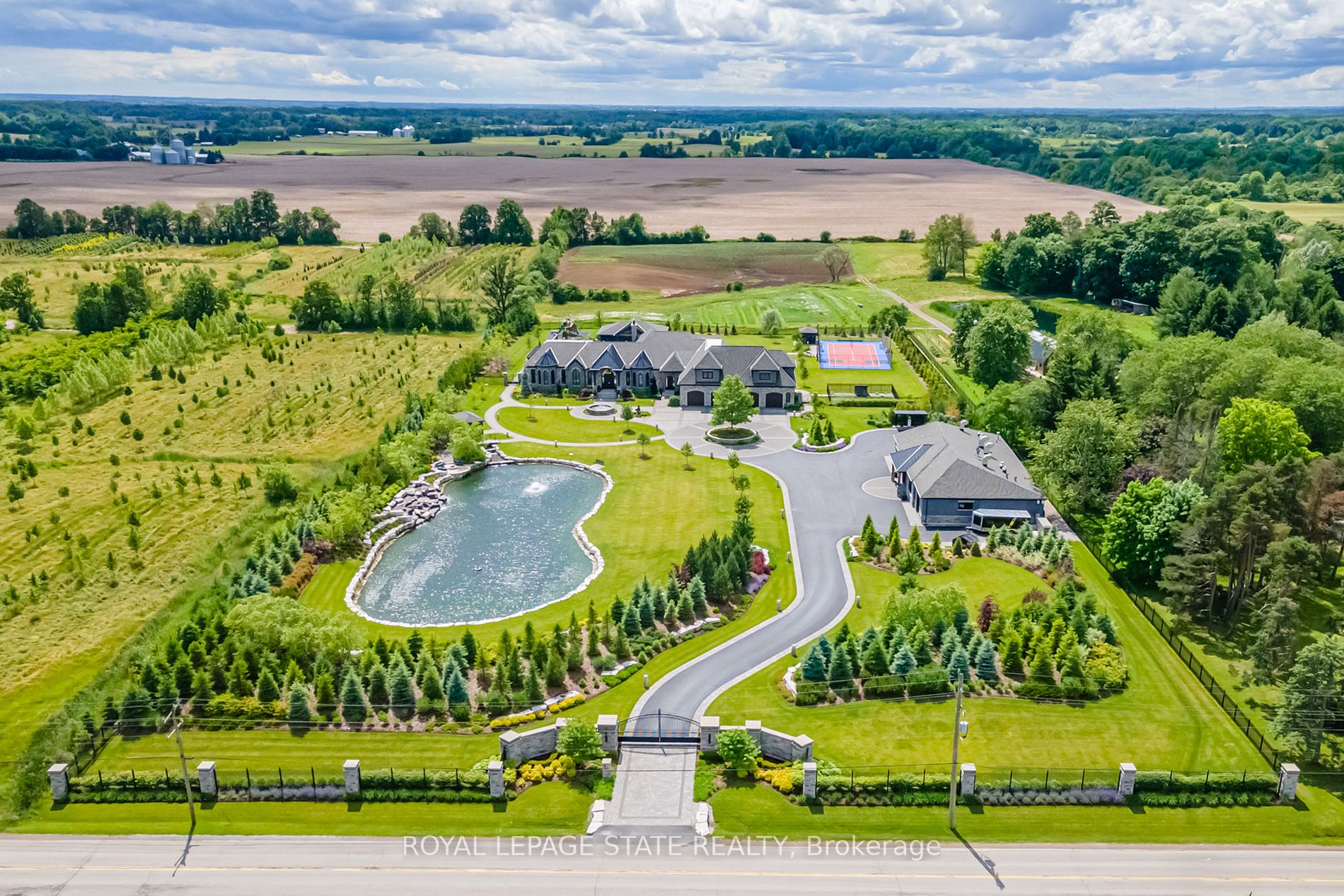 Set amidst a 5.2-acre estate, this extraordinary 26,000+ sq ft mansion offers unparalleled luxury and privacy. The gated and secured property features a stunning 1/3-acre aerated pond leading to a sprawling contemporary bungalow with lofted in-law quarters and a 5,210 sq ft detached garage with lounge, wash bay, and private gas pumpideal for car enthusiasts.Surrounded by serene countryside, yet minutes from the heart of Ancaster, the renowned Hamilton Golf & Country Club, and Highway 403, offering both seclusion and convenience. Inside, every room showcases soaring 14 to 18-foot custom moulded ceilings, 32-inch porcelain flooring, and the highest quality materials and craftsmanship. The state-of-the-art home features whole-home automation by Control4. Spacious living areas feature custom granite walls with Town & Country fireplaces. A gourmet kitchen is equipped with top-tier appliances, including Sub-Zero, Thermador, and Miele. The luxurious lanai is perfect for entertaining, with heated Eramosa flagstone, a full outdoor kitchen, 72 Woods gas fireplace, and phantom screens. The opulent primary suite includes a private patio with hot tub and an expansive dressing room. The ensuite features heated herringbone floors, a soaker tub with fireplace, towel warmer drawers and a digital rain shower. The opposite wing offers three additional bedroom suites, each with walk-in closets and ensuites. A Cambridge elevator provides access to the entertainers dream basement, with a party room, full bar, professional gym with sauna and steam shower, games room, and a state-of-the-art home theatre. This 24-seat Dolby Atmos theatre features a 254-inch screen, 24-foot ceiling height, and a Kaleidoscope movie server for the ultimate cinematic experience. Outdoor amenities include a 35 x 75 heated pool, a 14-person hot tub, and an entertainment cabana with a media area and hosting bar. A regulation-size sports court and a childrens playground complete this family-friendly estate.