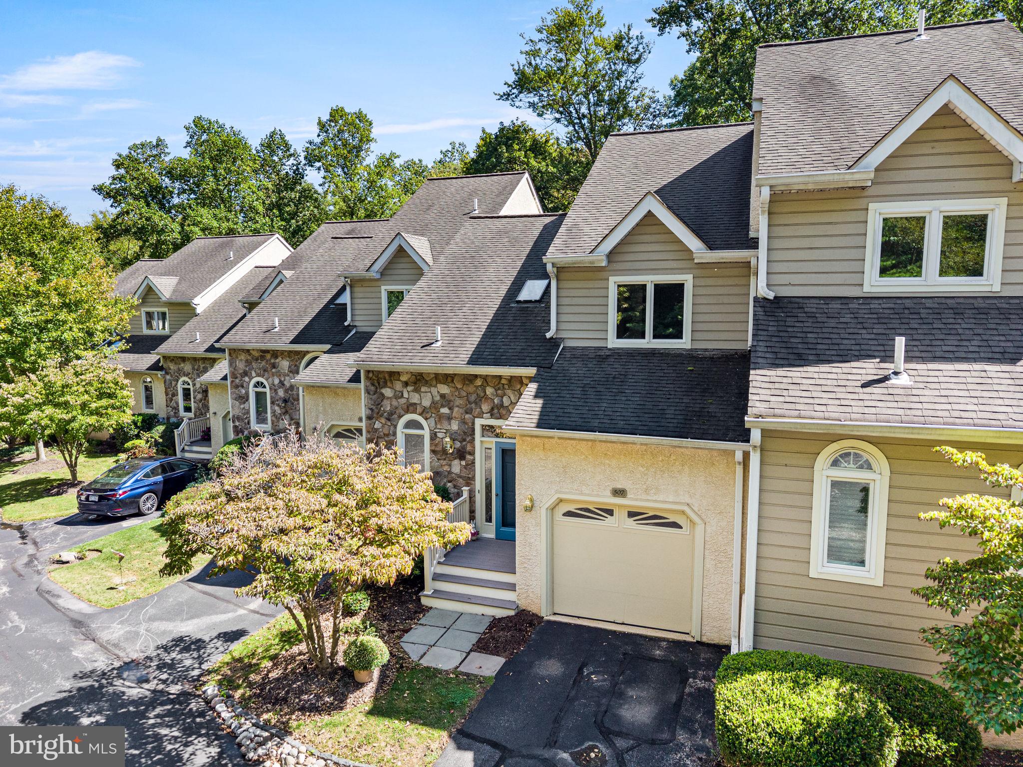 Welcome to the Village of Earles Lake, a lovely townhouse community in Newtown Square tucked away behind Greene Countrie Village. This spacious three-Bedroom, two-full and two-half-Bath home with a first floor Primary Bedroom suite offers a thoughtfully designed open floor plan with abundant natural light, generous storage, and beautiful views of lush greenery and mature woods. A driveway and attached one-car garage provide convenient parking, with ample guest parking available throughout the community.Step onto the welcoming front porch, where a charming blue front door with stained-glass sidelight, opens to a bright and inviting freshly painted (2026) interior with beautiful hardwood floors, a two-story foyer and an open turned staircase. A convenient coat closet and powder room with stained-glass window are to the left with the garage access on the right. Next is the Eat-in Kitchen with ample cabinetry, Corian countertops, recessed lights and a ceiling fan, open to the Dining Room. The adjacent Living Room is a standout space, featuring a vaulted ceiling, skylights that fill the room with wonderful natural light, and a gas fireplace. Sliding glass doors lead to a brand-new Deck (2026) overlooking the woods, creating a private and peaceful setting for morning coffee, outdoor dining, or relaxing among the trees.The first-floor Primary Suite offers exceptional convenience and privacy. The spacious Bedroom with vaulted ceiling, features a wall of windows overlooking the wooded surroundings, along with a walk-in closet and an additional closet for storage. The generously sized ensuite Primary Bathroom includes two separate sink vanities, a soaking tub, stall shower, and medicine/linen closet.The turned staircase with painted risers and a white banister leads to a versatile Loft with brand-new neutral carpeting that continues into both bedrooms (2026). Overlooking the Living Room below, the Loft features recessed lighting and a ceiling fan and offers an ideal space for a home office, reading area, or additional gathering space. Two additional Bedrooms, each with a lit ceiling fan and a double-door closet, are serviced by the Hall Bathroom with a tub/shower combination.Take the open turned staircase to the finished Lower Level that expands the home's living space with a spacious, carpeted recreation area, multiple windows, and sliding glass doors that bring in wonderful daylight and access to a small patio outdoors. Multiple closets provide additional storage, while a second Powder Room adds convenience. The Laundry Room with washer, dryer, and utility sink rounds out the lower level.This home combines the ease of townhouse living with the privacy and natural beauty of lush greenery and mature woods. With three levels of Living space, a first-floor Primary Suite, brand-new Deck (2026), carpeting (2026), New HVAC (2017 with annual maintenance plan), attached Garage, and abundant guest parking, this is a home designed for both comfortable everyday living and effortless entertaining. Conveniently located just minutes from all the shops and restaurants in Newtown Square and Wayne as well as commuting routes.