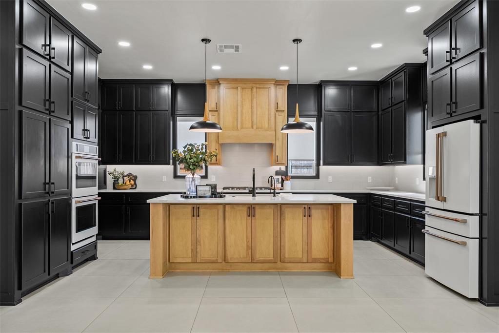 15444 Bonita is a beautifully finished home with the upgrades already in place—truly better than new! The versatile layout features two bedrooms on the main level, with two additional bedrooms and a large bonus room upstairs, providing a separate and versatile living space. The striking kitchen is the centerpiece of the home, showcasing a spacious island, upgraded appliances, abundant soft-close cabinetry and a beautiful mix of rich black cabinetry and warm natural wood accents. A walk-in pantry with extensive built-in shelving, countertop space and a microwave oven provides exceptional storage and functionality. The living area is highlighted by a fireplace with custom wood detailing creating a warm architectural focal point. Custom window treatments and carefully selected finishes add to the home's polished, move-in-ready feel. The primary suite is complemented by a spa-inspired bath featuring dual vanities, a freestanding soaking tub, walk-in shower with floor-to-ceiling tile and sleek black fixtures. An impressive walk-in closet offers extensive custom built-ins, shelving, hanging space and drawer storage. Outdoor living continues on the covered patio with fireplace, perfect for relaxing or entertaining throughout the year. Additional upgrades include a home generator for added convenience and peace of mind. Located in desirable Deer Creek Village, residents enjoy outstanding neighborhood amenities including a clubhouse, swimming pool, basketball court, playground and walking trails.