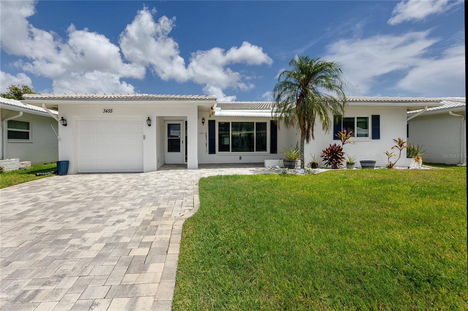 Mainlands of Tamarac by the Bay is an active 55+, golf cart friendly community in Pinellas Park where the lawn care, the irrigation, and the upkeep are somebody else's job, and this fully remodeled two bedroom, two bath home sits on a dead end street with no through traffic and more than 1,600 square feet of easy one level living.The 2024 renovation reached every room. The kitchen anchors the open floor plan with an oversized center island in quartz, an island mounted stainless range hood, new stainless appliances, and a workstation sink with a built in cutting board, and because the island seating faces the living and dining areas, whoever is cooking stays in the middle of the conversation instead of stuck around a corner. Wood look plank flooring runs throughout, and the sight lines carry from the front door clear through to the back of the house.The primary suite includes a walk in closet and a fully updated ensuite bath, while the second bedroom offers dual closets, a genuine advantage for guests or a home office. The second full bath was remodeled in the same contemporary finish.The expensive items are already done: PGT WinGuard impact windows with vinyl frames, SolarBan 70 low E glass and argon fill in 2024, a new tile roof in 2024, a Trane 3.5 ton HVAC system, a 2022 water heater, and a driveway repaved in 2022. Monthly maintenance covers lawn care, irrigation, water, cable TV, internet and Wi-Fi, trash, sewer, and recycling, and the community adds a heated pool, clubhouse, shuffleboard courts, and a social calendar that stays full year round.Pinellas Park puts you in the middle of the county, with the US 19 corridor and everyday shopping close by, HCA Florida Largo Hospital and the Bay Pines VA campus within an easy drive, St. Pete Clearwater International roughly 15 minutes out, and downtown St. Petersburg, the Gulf beaches, and Tampa International all within about 20 to 30 minutes.