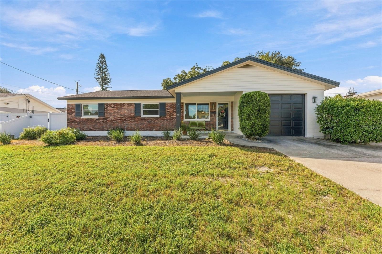 Welcome home to a secure, private retreat just minutes from the coffee shops, restaurants, and breweries that make Seminole Heights one of Tampa's most loved neighborhoods, all with an easy commute to downtown. This totally renovated 1960s home blends mid-century character with modern updates, starting with a welcoming front porch made for meeting neighbors and enjoying evening conversations. Inside, an open concept living, dining, and kitchen layout flows across refinished terrazzo floors that deliver true mid-century style and couldn't be easier to clean. The brand new kitchen features cabinets to the ceiling, clever hidden drawers for extra storage, and a bar that extends your prep space while adding extra seating for guests. The oversized laundry room is flexible enough to serve as a home office, playroom, gym, or pantry. Both bathrooms keep their charming original tile, now paired with new sinks, toilets, fixtures, and cabinetry for an updated look and added storage. Out back, the large yard is enclosed by new vinyl fencing that offers privacy and plenty of room to play, garden, or add a pool. The clean garage includes a new opener with exterior access. Peace of mind comes standard with a 5 year old roof, new indoor plumbing and water heater, new hurricane impact windows and back doors, new electrical switches and outlets, an updated electric panel, new baseboards and door molding throughout, redone closets, new outdoor lighting, and fresh paint inside and out. With no HOA and Seminole Heights right around the corner, this one checks every box.