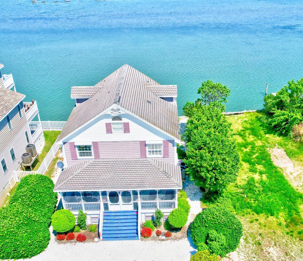 Coastal Waterfront Home with PANORAMIC & Sunset Views! This Large Three Bedroom, Two Bath Home boasts 1800 square feet with Views from Every Room. West Sunset Views and East Downtown Chincoteague Channel Views and Amazing Views of the Island. Nice Cross Breezes! Dollars Spent on this home with top-of-the-line Hardi plank Siding, Large Double Decks overlooking the Bay, Custom Electric Hurricane Shutters for Every Window and Glass Door. A large Front Screened Porch. Marble Floors, Central Vac on both levels, Custom Plantation Shutters, Security System, First Floor Primary Suite, New Bulkhead & Dock, (3yrs), New H2O Line, Dual Zone HVAC, Irrigation System, and more. Beautifully Landscaped. Located away from the traffic for peace & Quiet yet close enough to join the fun!