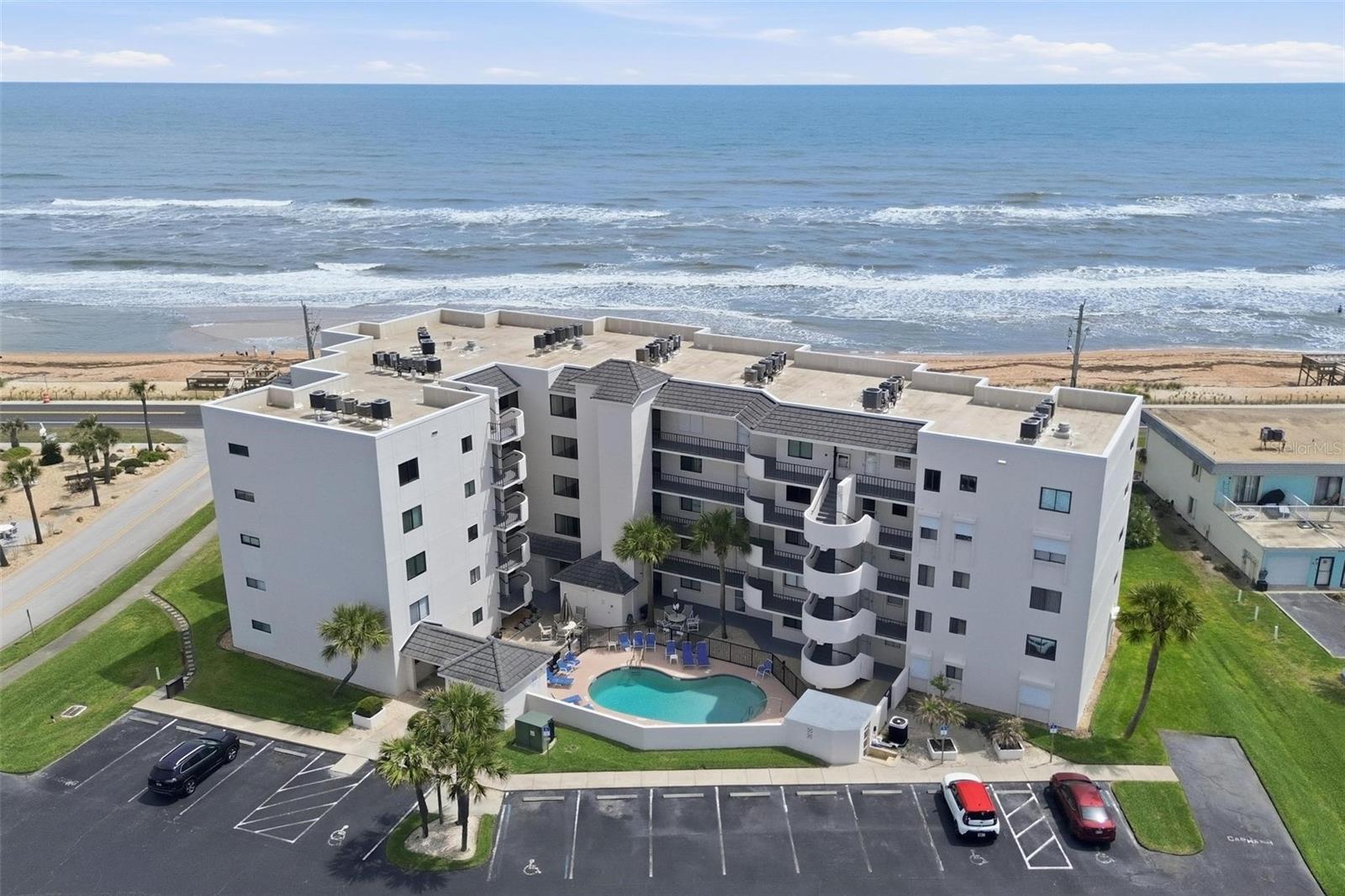 Come see it before it's gone! Welcome to your coastal retreat in Leeward Winds, nestled in the heart of Ormond By The Sea. This 2-bedroom, 2-bath end unit sits on the first floor and offers ocean views along with the ease of ground-level living — no stairs, no waiting on an elevator, just walk right out and you're steps from the sand.As an end unit, this condo boasts more windows than any other floor plan in the building, flooding the open layout with natural light and coastal breezes from multiple exposures. Wood-like ceramic tile flows throughout, and the kitchen and baths are original to the unit and ready for your vision — a rare chance to renovate to your own taste and build equity in a building where units seldom become available. Hurricane shutters on the windows and sliding doors mean storm season is one less thing to worry about, giving you true lock-and-leave peace of mind.Relax on your private patio overlooking the ocean, the perfect place to watch the sunrise or unwind to the sound of the waves. Leeward Winds is a well-maintained oceanfront building with a low $625 HOA, water and internet included, and fully funded reserves offering a sense of exclusivity and community just steps from the beach. Bring your ideas and make this slice of paradise your own!