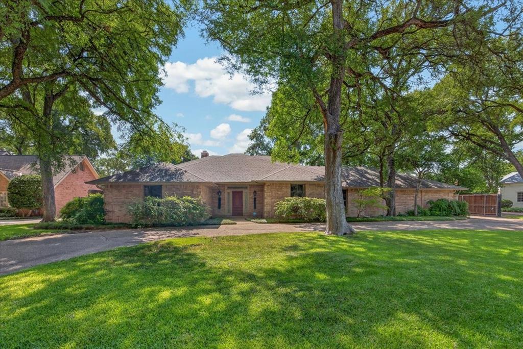 Spacious, one-story home on an expansive lot with mature trees in sought-after Overton Woods! This 3,424 square foot residence has four generous bedrooms, three full baths, and rich hardwood floors throughout the main living areas. The inviting living room is anchored by a striking wood-burning stone fireplace. The well-appointed kitchen overlooks this space and boasts beautiful custom cabinetry with ample storage, a gas range, and a lovely, casual dining space. The elegant, formal dining room is ready for holidays and gatherings. The oversized primary suite includes a versatile bonus room addition, currently a home gym and ideal as a private office, sitting room, or second living area. The secondary bedrooms are well-proportioned. A two-car rear-entry garage keeps the front elevation clean. Majestic mature trees provide shade and privacy. Single-level living, a generous lot, and an Overton Woods address. Schedule your private showing today!