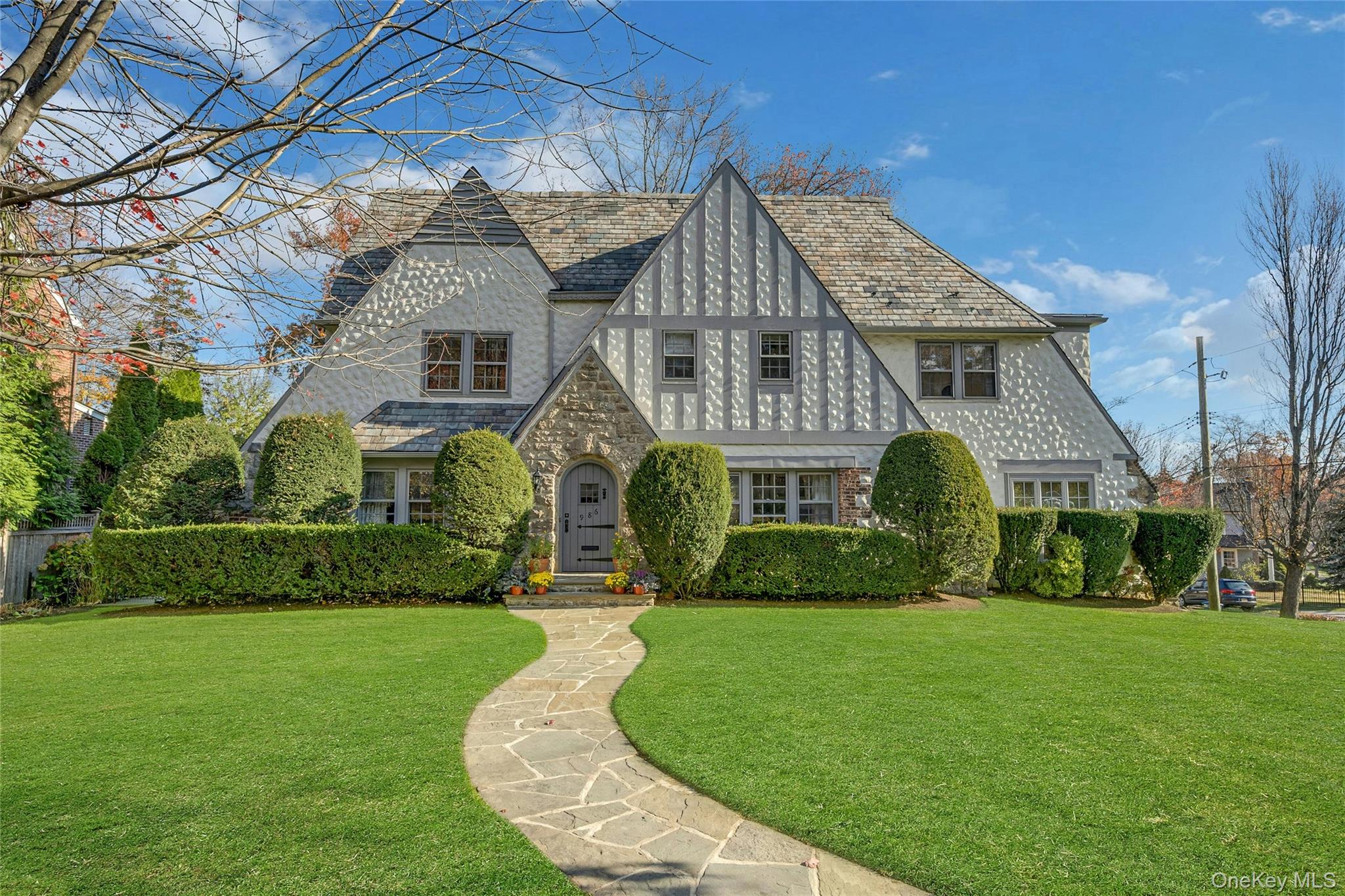 Picture-perfect Tudor on a spacious corner lot, just steps from Prospect Elementary School, playground, and sports fields!  As you step inside, you'll be greeted by a bright and sunny interior seamlessly flowing with beautiful hardwood floors, arched doorways and charming details that set this home apart. The elegant living room boasts a striking stone fireplace, creating a warm and inviting gathering space, a cozy sunporch/den provides the perfect spot to relax, while a formal dining room with gorgeous leaded glass windows add to the home's character.  A modern kitchen with direct access to a large private patio is ideal for both entertaining and everyday living. Upstairs, the oversized primary suite boasts a renovated bath, double sinks and ample closet space, accompanied by three additional bedrooms and an updated hall bath. The finished third floor offers a 5th bedroom/office, full bath, and attic storage, while the lower level provides versatile space for a playroom or gym. Don’t miss this exceptional home in Pelham Manor in a coveted neighborhood—your dream home awaits!