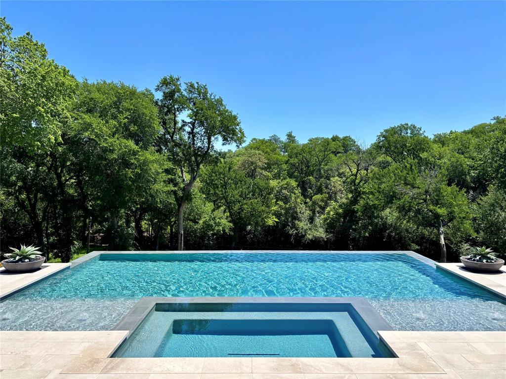 NOW COMPLETE, brand new construction on Dallas’s most iconic street, known as Billionaire’s Row. Poised on 2.2 expansive acres along Bachman Creek, 10010 Strait Lane blends craftsmanship, elegance, & luxury. Interiors ft soaring ceilings, clean lines, & floor-to-ceiling Kolbe windows. Designed for comfort & entertaining, chefs kitchen boasts 2 La Cornue dual-fuel ranges (10-burners total), Subzero, Wolf, & Miele appliances, & Thomas OBrien chandeliers. Catering kitchen includes elevator access to support events with ease. Sunroom & Formal Living space soar w 24 ceilings, glass walls, & Vida chandelier. Owners wing ft vaulted ceilings, fireplace, indoor outdoor sitting areas, Julie Neill chandelier, spa bath w Bain Ultra tub, dual water closets, beverage bar, towel warmer, Nobu Ribbon tile (Spain), Kalta Fiore marble, Kelly Wearstler & Arteriors lighting. 2 walk-in closets, Hers w island, hidden shoe, handbag, & jewelry closets; His w safe & luggage storage. Other amenities include elevator, wellness retreat for massage & fitness, opt 1,600-bottle glass wine room & or lower-level wine vault, golf sim rm, craft & music rm, 3-tier theater, & study w fireplace. Entry ft 25 ceilings, 23-light John Richard chandelier & oak herringbone floors. 3 utility rms (1 per floor), mudroom w dog shower. Outside ft screened loggia w fp & heaters, outdoor kitchen w pass-through window to main kitchen, negative-edge pool, spa, sun deck, & opt fire pit create a resort retreat. 4,181 sf air conditioned 10-car garage that doubles as an event venue. 8 terraces include cigar balcony, primary terraces, upstairs suites, front colonnade, & back loggia. Landscape lighting, optional tennis or sport court. Surrounded by mature trees & creek, offering privacy in prestigious Preston Hollow neighborhood. Built with concrete walls & steel supports, ensuring bunker-like strength, 10010 Strait Lane offers a once-in-a-lifetime opportunity in the heart of the private school corridor.