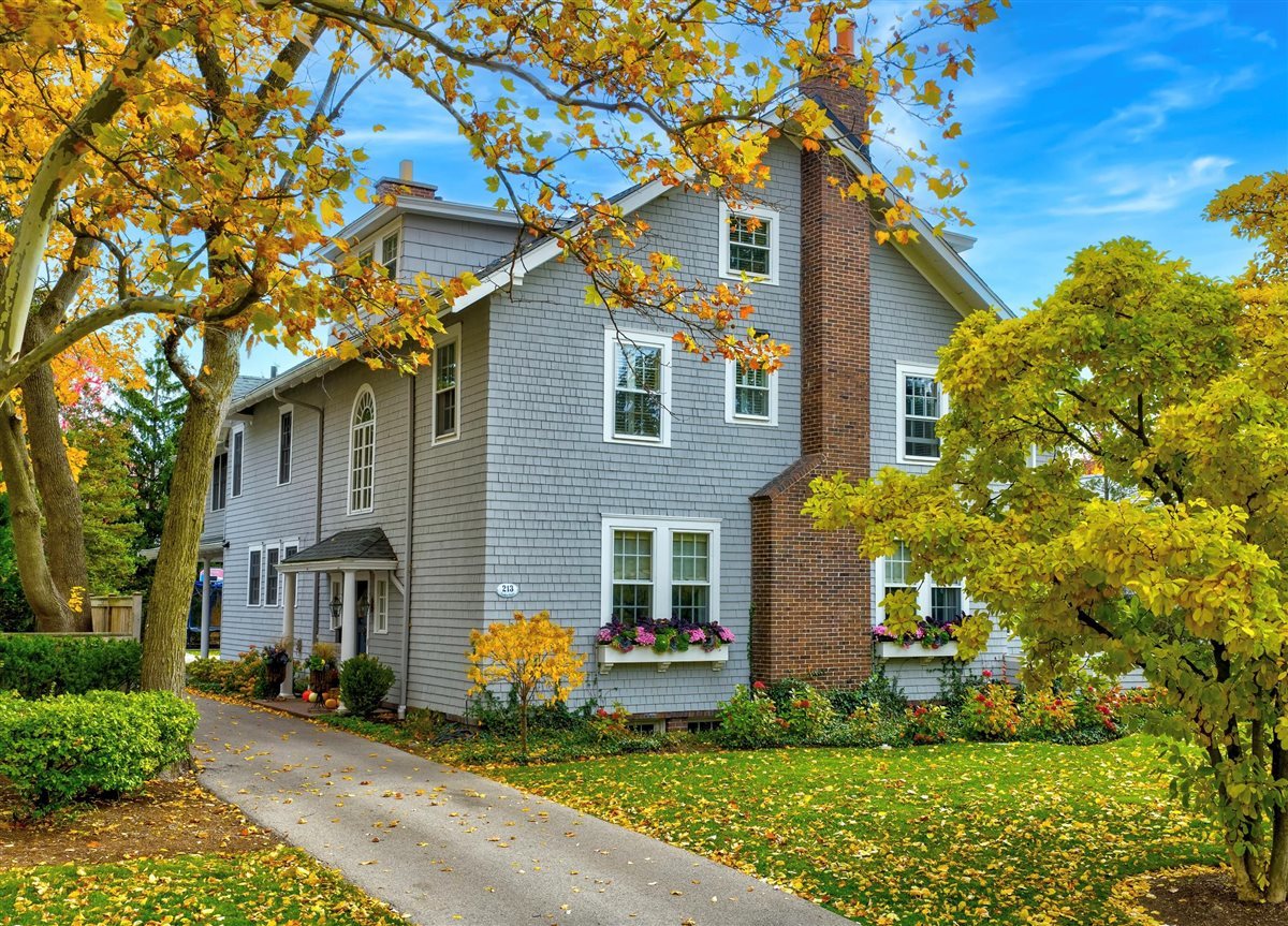 Centrally located in a  premiere "get to everything" A+ location, this quintessential North Shore coastal shingle home delivers the best of both worlds. Thoughtfully remodeled and reimagined by notable North Shore architect Paul Konstant that beautifully blends classic character with a refreshed, modern floor plan that marries timeless architecture with designer-perfected living. Step inside to a gracious foyer that opens to the formal living and dining rooms. Sun-drenched living room shines with restored original built-in bookshelves & accented by WBFP with a fab Chicago common brick surround creating a warm welcome. Living room flows effortlessly into stoic Polo lounge/office painted in a cozy Farrow & Ball liquorice, custom built-ins, huge bay window, custom Ralph Lauren window treatments & classic window seat. Elegant dining room, bathed in natural light, connects seamlessly to the butler's pantry opening to the Chef's kitchen - the hub of this extensive first floor. Crisp white cabinetry, s/s appliances, an oversized breakfast island outfitted in gorgeous Villa Bianco marble with seating for 4. Directly off the kitchen, mudroom with back door entrance and 2nd powder room. Bright breakfast room bathed in light w/ thoughtfully designed built-in command center connects directly to the new phenomenal Great room addition with soaring vaulted ceilings, intricate trim work, a window bench flanked by custom built-ins, a soapstone surround FP, and French doors  that open to the covered back porch with FP that overlooks the lush, beautifully landscaped 1/2 acre grounds. Second floor with 4 bedrooms: two share a Jack & Jill bath, one ensuite, and bedrooms two and three share a cheerful sun-drenched tandem room with custom built-in desks - a perfect homework space or kids' hangout. Large primary suite is a true retreat with a stunning newly redone spa bath featuring Ann Sacks tile, thick white marble counters, soaking tub, dual vanity, and a marble-clad walk-in shower. Large walk-in closet and best yet, a private second-floor balcony. 3rd floor with 2 additional bedrooms that share a hall bath - ideal for guests. Incredible new lower level dug out with radiant heat, soaring ceilings with natural light in the large rec room. Pretty full bath with caesarstone grey c-tops, subway tile, and white cabinetry. HUGE storage space on the unfinished side with craft area and ample closets. Just steps from town, train, and all schools including Faith Hope, NSCD, New Trier & Loyola, 213 Linden is the kind of home that feels magical in every season - from summer nights in the backyard to cozy holidays by the fire. A timeless Winnetka classic that is turn key charming all American beauty!