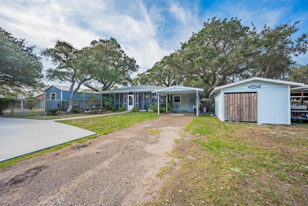 Set on the quiet Lamar Peninsula, 19 Estates offers a rare combination of comfortable living and built-in income potential just minutes from St. Charles Bay. The main residence is a well-designed single-story home with four bedrooms and one-and-a-half baths, featuring an open and airy living space, vinyl plank flooring, and a newer A/C system with dehumidifier for year-round comfort. The kitchen flows seamlessly into the living and dining areas, making it ideal for everyday living or gathering with friends and family. A large screened front porch extends the living space outdoors, while the expansive fenced yard provides privacy, room for recreation, and space to accommodate RV parking. Complementing the main home are two separate, fully furnished cottages—each thoughtfully designed to offer privacy and flexibility. The first cottage, built in 2014, includes two bedrooms, one bathroom, a full kitchen, a screened porch, and its own fenced yard. The second cottage, completed in 2022, also offers two bedrooms and one bath with an open living and kitchen layout, a newer A/C system, tankless water heater, screened porch, and fenced yard. Surrounded by some of the area's best fishing, birding, and coastal scenery, and located near Goose Island State Park, the Big Tree, and Rockport's dining, shopping, and beaches, this property is ideal as a family compound, coastal getaway, or income-producing investment.