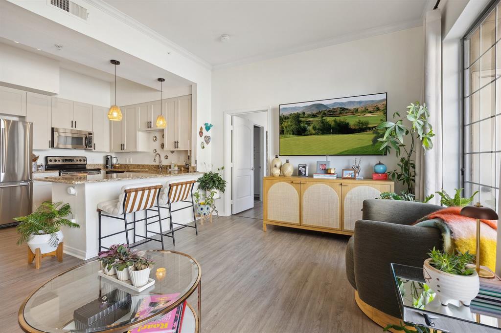 Living room with ornamental molding and light wood-type flooring