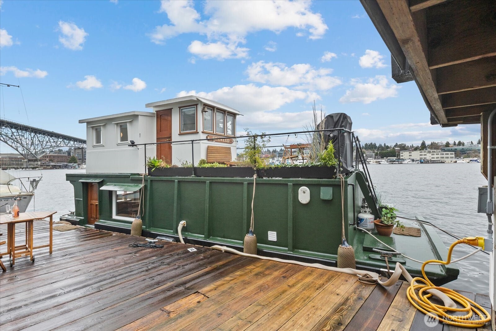 Welcome aboard Seaweed, a one-of-a-kind floating retreat on the coveted waters of Lake Union. This beautifully crafted houseboat blends warmth, character, and modern comfort, offering a lifestyle that’s as relaxing as it is inspiring. Step inside to discover intricate woodwork, creating a rich, inviting interior that feels both timeless and cozy. The open living space is filled with natural light and thoughtfully designed to maximize both comfort and functionality, whether you’re enjoying a quiet evening in or entertaining guests. The luxurious jetted tub invites you to unwind and relax after a day on the water. Everyday living is made easy with the convenience of onboard laundry, allowing you to fully settle into life afloat without compromise. One of Seaweed’s most inviting features is the upper deck, a perfect vantage point for morning coffee, afternoon reading, or taking in vibrant Lake Union sunsets. This outdoor space extends your living area and offers a seamless connection to the surrounding water and skyline. Seaweed offers flexibility for a variety of lifestyles, with both rentals and pets permitted, making it an appealing option for homeowners and investors alike. The leased slip has space for 2 boats and rents for $3,000/month + liveaboard fee of $500/month. Whether you’re searching for a peaceful full-time residence or a weekend escape, Seaweed delivers an exceptional opportunity to experience the charm and tranquility of life on Lake Union.