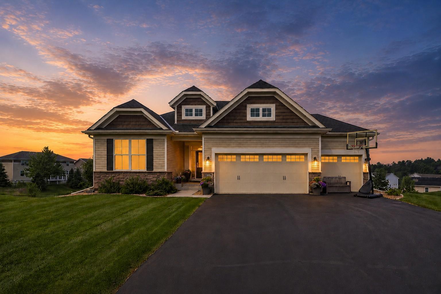 Occupying one of the neighborhood's most coveted settings, this meticulously crafted residence pairs architectural integrity with an exceptional sense of place. Set on nearly half an acre amid thoughtfully designed landscaping, the home makes a striking first impression while offering sweeping views. Beyond the front door, an impressive foyer frames the landscape beyond, establishing an immediate connection to the home's exceptional setting. The floor plan is thoughtfully intuitive, planned for the demands of everyday enjoyment and entertaining. Anchored by a floor-to-ceiling stone fireplace and a dramatic wall of windows, the living room is bathed in natural light throughout the day. At the heart of the home, the beautifully appointed kitchen features custom cabinetry, quartz countertops, a glass tile backsplash, and an expansive center island that encourages conversation while remaining highly functional. A generous walk-in pantry and adjacent laundry room provide everyday convenience without compromising the home's thoughtful design. The dining area opens to a maintenance-free deck, where panoramic 180-degree views stretch for miles and create an extraordinary backdrop for morning coffee or evening entertaining. The main-level primary suite offers a peaceful retreat overlooking the backyard, complemented by a spacious ensuite with dual vanities, a soaking tub, separate shower, and an oversized walk-in closet. Two additional bedrooms and a full bath are thoughtfully positioned on the opposite side of the main level, while a dedicated mudroom provides an elegant solution for Minnesota's changing seasons. Designed with flexibility in mind, the walkout lower level extends the home's living space with a generous family room that flows seamlessly outdoors, along with a guest bedroom and full bathroom ideal for overnight visitors. Extensive upgrades further elevate the property, including maintenance-free decking, an expansive paver patio, and an insulated three-car garage featuring epoxy floors, premium built-in cabinetry, and many custom storage racks. The outdoor spaces are equally compelling, offering a true retreat with beautifully curated landscaping, a covered paver patio, a maintenance-free deck, a set of stairs that lead to a raised garden bed and lush backyard, and even nine fruit trees. Every detail reflects exceptional care and pride of ownership resulting in a residence with seamlessly enduring craftsmanship, and an extraordinary setting. If these are your priorities, then this home is worthy of your attention.