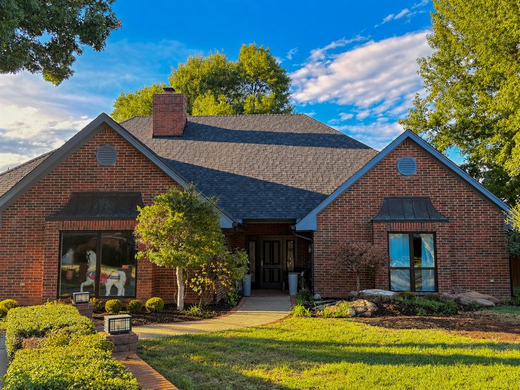 Start your morning with lake views and end the day relaxing beside your own pool. Tucked into a cul-de-sac in Norman’s gated Crystal Lakes community, this distinctive brick home brings together spacious single-story living and inviting outdoor spaces.Approximately 4,040 square feet includes four bedrooms, three full baths, and one half bath. Two primary suites offer flexibility, while the fourth bedroom features built-in cabinetry and access to a Jack-and-Jill bathroom. Wood flooring, a fireplace, and generous gathering spaces create a welcoming interior. In the main living room, a beamed ceiling and arched windows above the patio doors add architectural character and natural light.The kitchen offers plenty of room to cook and gather around a large island with gas cooktop, sink, and seating. Light countertops contrast with dark cabinetry, complemented by stainless steel double wall ovens and distinctive pendant lights. The adjoining dining area opens to the patio, and a separate wet bar includes wine storage.Covered and open patios, a private in-ground pool, and a scenic lake backdrop extend the living space outdoors. Situated on approximately 0.41 acre with mature trees, the home also includes a spacious laundry room with sink and extensive cabinetry, plus an attached two-car garage.