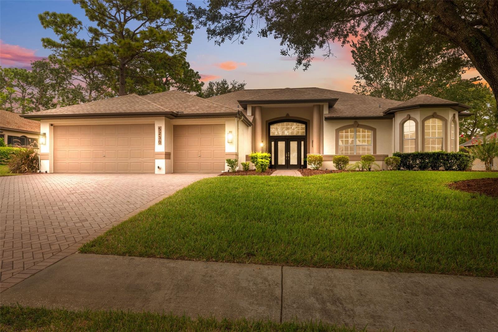 Tucked within the exclusive gated community of Silverthorn, this beautifully appointed 3-bedroom, 3-bath home with a 3-car garage and additional office blends refined comfort with everyday functionality. Set on a prime golf-course lot, the property enjoys tranquil views and an unbeatable location: a manicured front lawn and mature landscaping frame the paver driveway and grand facade, where custom etched-glass double doors open to a light-filled foyer accented by crown molding and a beaded chandelier. Inside, vaulted and tray ceilings soar above an expansive open layout finished in wide-plank, wood-look luxury vinyl flooring. The chef’s kitchen showcases stainless steel appliances, solid surface countertops, two-tone cabinetry, and a walk-in pantry, anchored by a bright breakfast nook that flows to the dining area. The living room centers on a white-washed stone electric fireplace with custom built-ins and floor-to-ceiling sliding glass doors that perfectly frame views of the screened lanai and sparkling pool. Outdoors, a screened lanai with a built-in outdoor kitchen and dining area creates an ideal setting for intimate evenings or lively gatherings. The primary suite is a true retreat with vaulted ceilings, pool views, private lanai access and a newly remodeled spa-style bath with a freestanding soaking tub, dual vanities, and a frameless glass walk-in shower. Two additional bedrooms offer generous space and storage, including one with a walk-in closet and private bath access. Surrounded by lush landscaping and sweeping golf-course vistas, the screened pool area provides privacy and resort-style living. Convenient to local attractions such as Weeki Wachee Springs State Park and Pine Island Beach, and with easy access to the Suncoast Parkway for commuting to Tampa and beyond, this home captures the best of Florida living in a prestigious golf community rich with amenities.