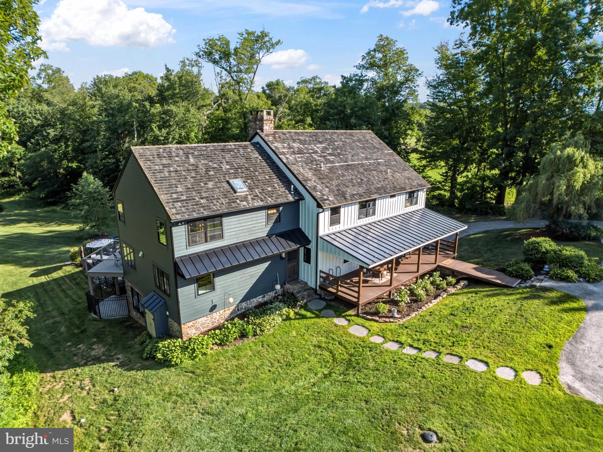Discover this stunningly reclaimed barn home, where historic charm meets modern luxury on a picturesque 13-acre parcel in the heart of Chester County. A maple tree-lined driveway welcomes you to this private retreat, where extensive updates blend seamlessly with the timeless architecture of the original structure. The home features all-new exterior siding and windows on the first and second floors, complemented by a new front door and patio door. A massive front porch with maintenance-free decking offers an inviting space to enjoy the surroundings. The roof is finished with beautiful cedar shake shingles. Outside, luxury amenities abound: a Carlton Pools kidney bean-shaped swimming pool with diving board, surrounded by extensive hardscaping perfect for entertaining. A serene pond with fountain and newly leveled dock provides a peaceful focal point, while thoughtful tree clearing has opened up natural light across the property while preserving complete privacy. Extensive fencing makes the land ideal for horses or other livestock.Additional outbuildings enhance the farm-like functionality: a three and a half-stall barn with a large hay loft, tack room, and brand new cedar shake roof, a storage shed on the backside of the barn, ideal for a woodworking shop, and a massive detached equipment shed featuring a 2-post lift, perfect for maintaining farm equipment, cars, or trucks. The property also offers the ability to lease an additional  4 acres from PECO.Step inside to find thoughtfully renovated living spaces that honor the barn’s heritage while delivering every modern comfort. The massive kitchen is a chef’s dream, boasting an enormous island, extensive inset paneled cabinets, reclaimed wood-style island cabinets, and a matching range hood. It features a commanding 6-burner, four-foot-wide range with side griddle, a four-foot-wide refrigerator/freezer, and a convenient wet bar with two mini refrigerators. The master suite is a luxurious retreat with a vaulted ceiling showcasing natural hand-hewn timbers as rafters and collar ties. The spacious master bathroom includes a six-foot-wide vanity with granite countertops, a tile walk-in shower, a soaking tub, and a cozy electric fireplace with stone veneer surround. A massive natural wood-look walk-in closet completes the suite. The great room impresses with its dramatic two-story vaulted ceiling, reclaimed hardwood floors, and natural hand-hewn timbers. A beautiful reclaimed stone two-sided fireplace serves both the great room and kitchen. Built-in cabinets and shelves add warmth and storage, while a formal dining room with two entrances sits just off the great room—complete with its own walk-in closet and built-in shelving for entertaining. The foyer and sitting area feature rustic terra-cotta tile floors and tongue-and-groove bead-board ceilings above the natural beams. A convenient half bath is located nearby, along with generous coat closets. The finished basement offers exceptional versatility with entertainment space and the fourth bedroom. Highlights include a walkout to the pool deck, flagstone floors, and a wood stove that efficiently heats the area. The fourth bedroom functions as a private oasis—currently used as a family room—with its own full bathroom, two spacious closets, and a wet bar with refrigerator. Additional amenities include: two geothermal units to ensure year-round comfort and efficiency; a whole-house water treatment system that delivers exceptionally clean, great-tasting water, and a guest quarters and lower level storage attached to the barn. Horseshoe trail and French Creek trails are not far for the avid horse rider, and the property is assessed under Act 319 - Clean and Green. This is a rare opportunity to own a property that masterfully combines historic barn architecture with high-end modern renovations and expansive equestrian/farm potential. Properties of this caliber do not come along often in Chester County.
