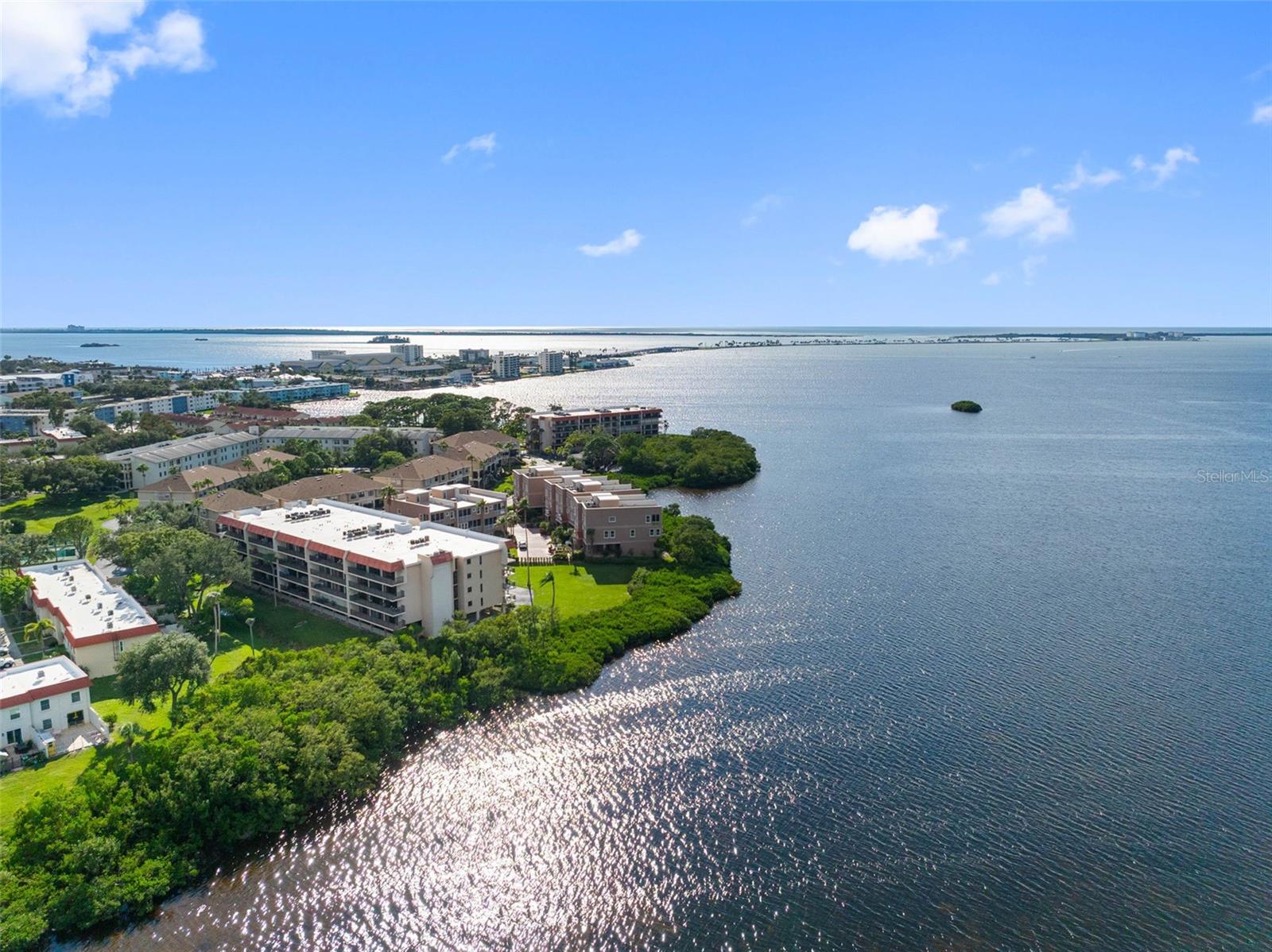 RARE TOP-FLOOR - PENTHOUSE WATERFRONT OPPORTUNITY IN DUNEDIN! Experience exceptional coastal living in this beautifully updated residence featuring breathtaking views of the Gulf and Intracoastal Waterway. With approximately 240 square feet of wraparound balcony space, this unique home offers a front-row seat to spectacular sunsets, dolphins, native water birds, and refreshing coastal breezes. Enjoy morning coffee, sunset cocktails, and year-round waterfront entertaining against an unforgettable natural backdrop. The open-concept interior features a quartz kitchen with abundant counter space, wood cabinetry, and stainless-steel appliances. Luxury vinyl plank flooring and recessed lighting create a cohesive, contemporary feel throughout. The spacious king-size primary suite offers direct balcony access, a walk-in closet, and a private ensuite bath. The second bedroom also enjoys water views and balcony access, making it ideal for guests, a home office, or additional living space. Located in an elevated, secure stilt building, this residence offers exceptional storage, including a bike room, and additional communal storage on the residential floor. Enjoy an outstanding array of waterfront community amenities, including a private beach, waterfront park with barbecue areas, heated swimming pool with shower, kayak storage, tennis and pickleball courts, and a clubhouse featuring a fitness center, library, and billiards. Ideally located across from the Pinellas Trail and near the Dunedin Causeway, you are minutes from Honeymoon Island State Park, Caladesi Island, and the charming shops, acclaimed restaurants, breweries, and golf courses of downtown Dunedin. Discover a rare combination of water views, updated interior, resort-style amenities, and the relaxed elegance of Dunedin waterfront living. Your coastal lifestyle awaits!
