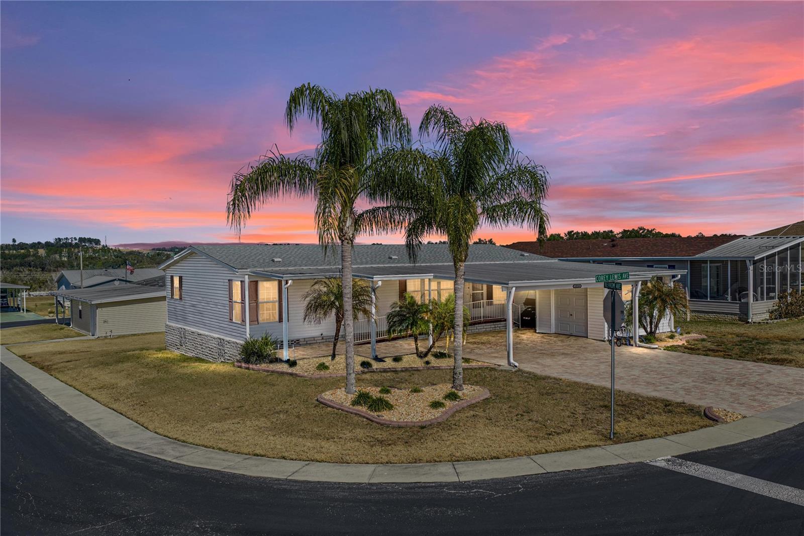 Fully Furnished, Handicap Accessible, a 2025 roof, and the golf cart is included?! This is a Grand Horizons home you do not want to miss! Set on a tropically landscaped corner lot, this 2013 home delivers the easy, resort-style lifestyle that makes this gated 55+ community so sought-after, and you own the land.  Your introduction to the property begins with an oversized two-car carport, wide paver driveway, a handicap-accessible ramp, and a dedicated golf cart garage, all wrapped in vibrant landscaping that immediately signals a warm welcome. Inside, the home opens into a light-filled, comfortable layout thoughtfully appointed with crown molding and ceiling fans in every room. The living room offers plenty of space to entertain with a smooth flow into the dining room and eat-in kitchen. It is a culinary lovers dream with a center island providing storage and breakfast bar seating, upgraded pendant lighting, a massive hidden walk-in pantry, a four-piece appliance package (including a brand-new 2025 refrigerator), and abundant prep space. The nearby laundry room keeps daily tasks within easy reach but out of sight. The primary suite sits in its own quiet corner of the home, offering privacy and calm with plush carpeting, crown molding, a generous walk-in closet, and an ensuite bath featuring dual sinks, an extra storage closet, a walk-in shower, and a new toilet. Two secondary bedrooms are tucked on the opposite side of the home, each with walk-in closets and convenient access to the home’s second full bath with a tub/shower combination- ideal for visiting guests. Outside, the corner lot and tropical trees create an inviting backdrop for relaxing mornings or breezy afternoons. And with notable upgrades such as full handicap accessibility, a 2025 roof, turnkey furnishings, and the included golf cart, this home is ready for its next chapter from day one. All of this sits just moments from the heart of Grand Horizons, where residents enjoy a bustling clubhouse, a sparkling pool, shuffleboard courts, and a full calendar of activities, all within easy reach of Zephyrhills’ best conveniences. Give us a call today for your private tour.