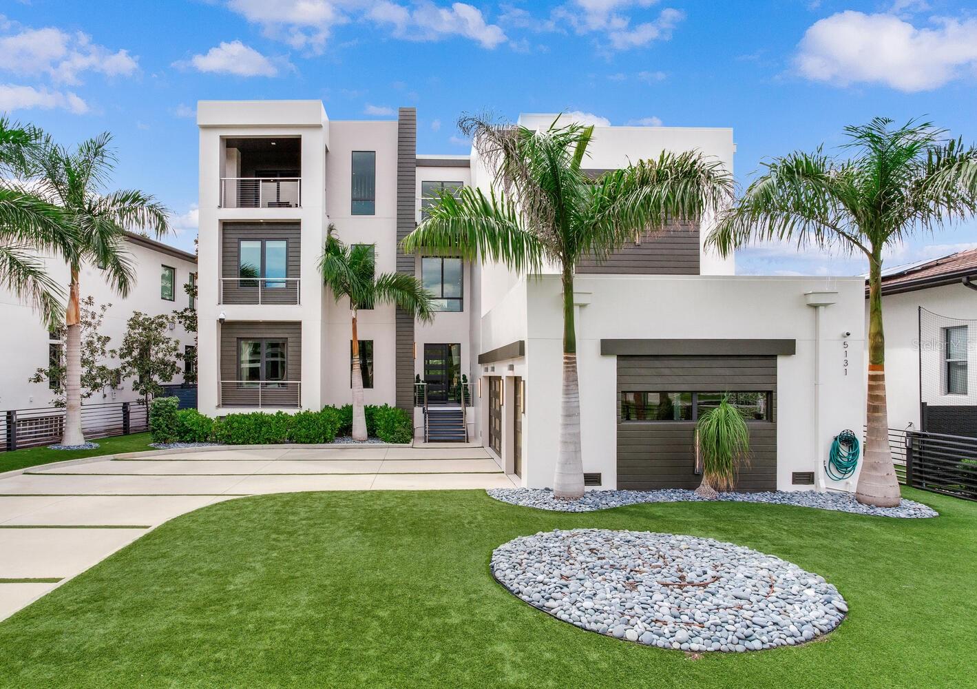 Breathtaking Three-Story Waterfront Sanctuary in South Tampa
Step into 5131 Neptune Way, a dramatic Malibu Modern waterfront masterpiece where sunlight dances through expansive windows, highlighting soaring ceilings and open, flowing spaces. Every room is meticulously designed, offering panoramic water views that create a serene and luxurious atmosphere throughout this 6,520 sq. ft. estate. With 6 generously sized bedrooms, 6 full bathrooms, a private office, state-of-the-art movie theater, personal gym, elevator, and an oversized 3-car garage, this home is as functional as it is breathtaking.
The first floor welcomes you with a mudroom, walk-in pantry, gourmet kitchen, dining room, living room, den, a large bedroom and a full bath, offering thoughtful spaces for both daily life and hosting. On the second floor, a spacious loft, laundry room, three bedrooms with full en-suite baths, and a state-of-the-art theater creates a versatile and comfortable family retreat. The third floor is designed for wellness and entertainment, featuring a gym, sauna, two bedrooms with a full bath, a large open entertainment area and an office. There is access to the terrace, an expansive outdoor sanctuary unto itself, complete with a gorgeous fire pit; perfect for entertaining or savoring serene waterfront sunsets.
The gourmet kitchen, a true chef’s dream, showcases custom cabinetry by Allikristé, premium Wolf appliances, a massive island, and a 200+ bottle wine cellar, perfect for intimate family meals or entertainment on a grand scale. Open concept living areas flow seamlessly to outdoor spaces, including an infinity pool and spa, summer kitchen with 40” grill and wet bar, a fire pit, and private boat dock with lift (10,000 lbs.), ensuring that every moment is spent in uninterrupted waterfront bliss.
Nestled in the Beach Park neighborhood, this home offers unparalleled privacy, elegance, and convenience, minutes from Tampa International Airport, Bayshore Boulevard, Hyde Park, Sparkman Wharf, top-rated schools, and St. Pete/Clearwater beaches.
5131 Neptune Way is not just a residence, it is an extraordinary lifestyle, combining sophisticated design, open airy spaces, and the ultimate in waterfront luxury.