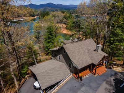 Welcome to your mountain-lake escape, where breathtaking, year-round views of Lake Hiawassee set the stage for an unforgettable lifestyle. Nestled in a vibrant golf cart-friendly community, this turnkey 2-bedroom, 2-bath retreat offers the perfect blend of relaxation, recreation, and investment potential.  Designed with comfort and connection in mind, the home features an open-concept living space filled with natural light and framed by stunning lake and mountain vistas. A charming loft provides additional sleeping or lounging space, while the lower-level flex area offers endless possibilities—create a home office, game room, or cozy den to suit your needs.  Step outside and enjoy the ease of a double carport and ample additional parking, making hosting family and friends effortless. After a day on the water or exploring the mountains, unwind on your deck and take in the peaceful surroundings.  This amenity-rich community elevates your experience with a swimming pool, volleyball and tennis courts, pickleball, ping pong, and a welcoming clubhouse. Spend your days cruising by golf cart, enjoying the social atmosphere, or heading down to the marina—where boat rentals make lake days simple and spontaneous.  Offered fully furnished and move-in ready, this home is ideal as a private getaway or a high-potential short-term rental. With views this stunning and amenities this abundant, the opportunity is truly unmatched.  Come experience the best of lake and mountain living—where every day feels like a vacation.