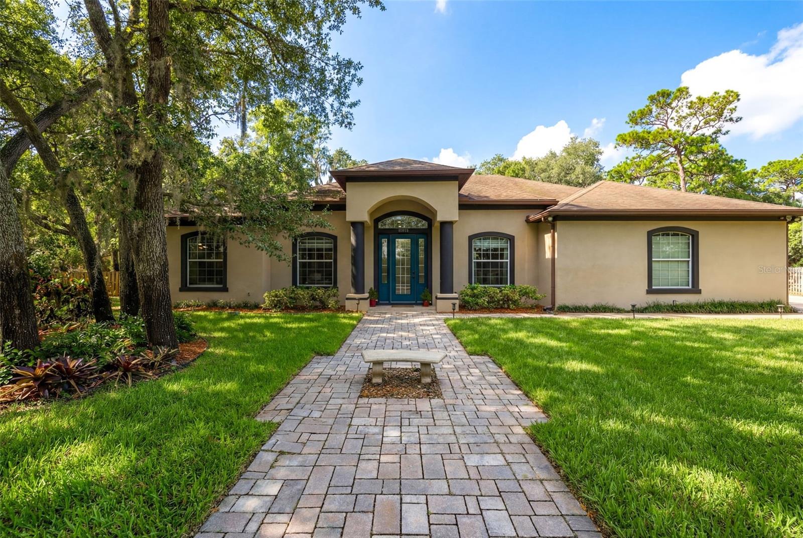 One or more photo(s) has been virtually staged. This multigenerational property sits on over ½ acre with no HOA. Nestled beneath mature oak trees, this single-story home offers 5 bedrooms and 4 bathrooms, blending traditional character with modern, resort-style features. Inside, you’ll find 12-foot ceilings, spacious light-filled living areas, and a split floor plan that provides both comfort and privacy. The primary suite serves as a private retreat, featuring two walk-in closets, an oversized bedroom, and a spa-style bathroom with a jetted soaking tub and generous layout. Each bedroom includes 10-foot ceilings, enhancing the open feel throughout the home. Triple glass doors lead to an outdoor living space designed for entertaining, including a screened-in patio of over 400 square feet with 12-foot ceilings, a pool and hot tub, and a fully equipped outdoor kitchen complete with its own bathroom and shower. With no HOA restrictions, the property offers flexibility for various uses. The outdoor shed provides potential for conversion into an ADU or detached mother-in-law suite, making it well suited for multigenerational living. Conveniently located near shopping, dining, and top-rated schools, this home offers space, versatility, and a desirable setting. Schedule your showing to explore the possibilities.