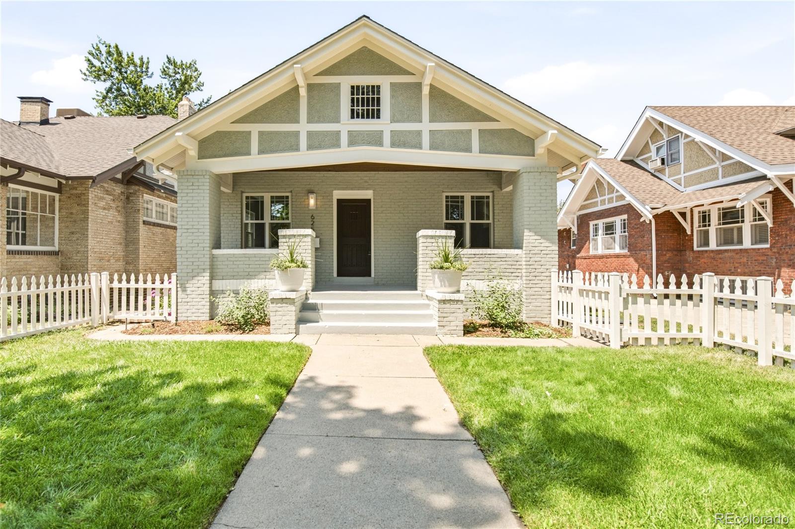 A classic Denver brick bungalow, fully remodeled for modern living; this is a home that merges timelessness with style and convenience. Cosmetic updates are complemented by a host of internal upgrades, including new windows, electrical wiring and panel, HVAC, radon system, and efficient appliances including an induction range. An idyllic white picket fence surrounds a lush front yard that leads residents onto a spacious and covered front porch. Inside, a gas fireplace grounds a living area that seamlessly flows into a dining room and nearby kitchen. The center island with seating maximizes the space for easy home gatherings. Tall ceilings crown an upper-level primary suite, complete with dual vanities, a walk-in shower, and a deep soaking tub. This level also hosts a wet bar and seating area — ideal for quiet morning coffee or additional space to entertain. The lower level is just as luminous with spacious recreation/storage area, a full bathroom, and additional bedroom space. Outside, a low-maintenance backyard and garage offer convenience for outdoor living. The coveted location places residents in the heart of it all: shops and restaurants on 6th Ave, Congress Park, Cheesman Park, and so much more.