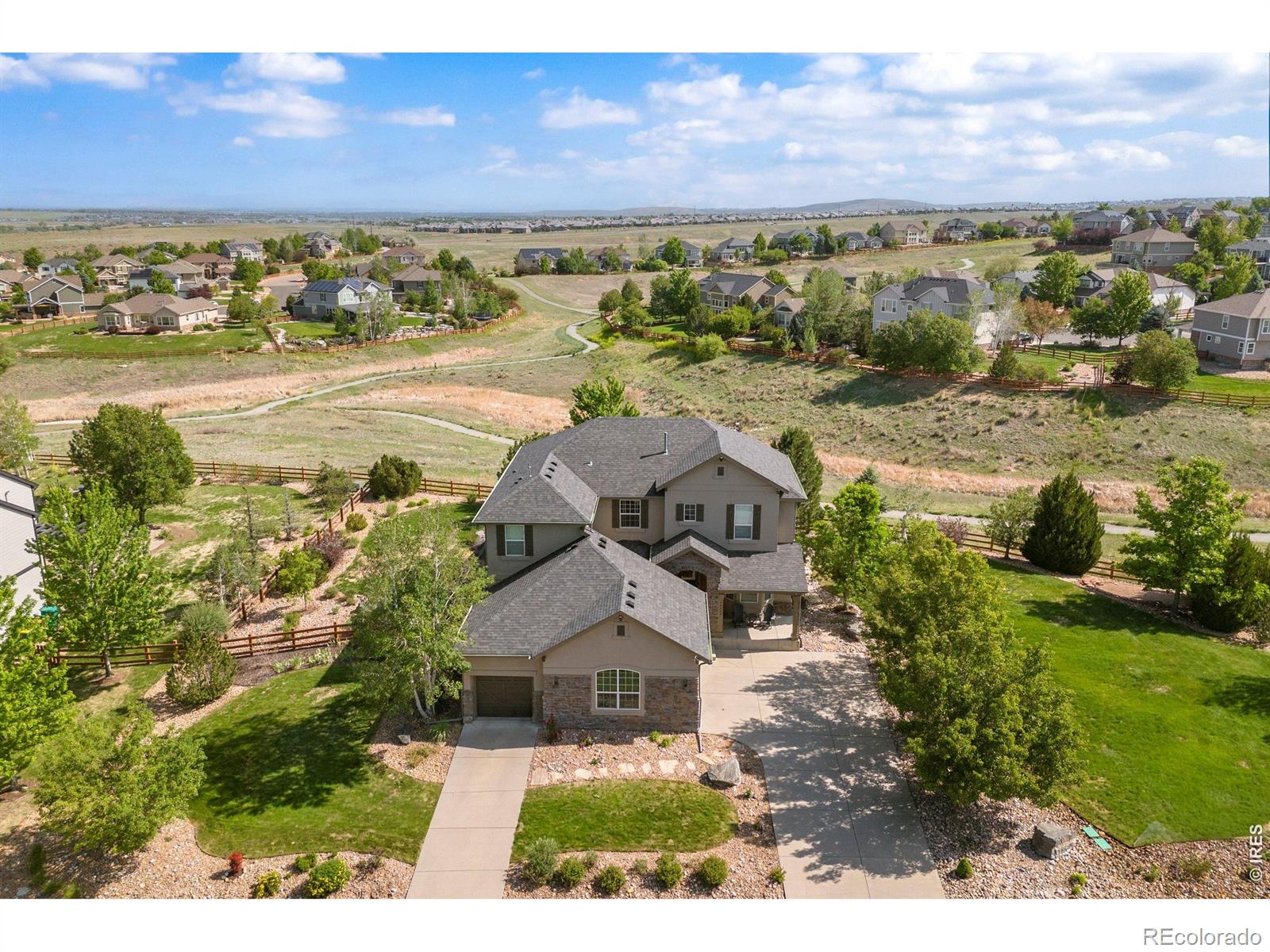 Perfectly situated on one of Wildgrass' most sought-after homesites, this exceptional property offers an expansive 1/2-acre setting with stunning mountain views and access to the highly regarded Boulder Valley School District. Surrounded by open space and neighborhood trails, this home truly captures the best of Colorado living. The beautifully landscaped backyard has matured into a private and peaceful retreat, featuring a tranquil water feature, spacious covered patio with built-in heaters, built-in grill and firepit, and a pre-wired hot tub pad. This outdoor space is special for entertaining and enjoying sunsets! Inside, thoughtful updates create a fresh, modern feel while classic white cabinetry provides timeless appeal. Modern LVP flooring flows throughout the main level, complemented by abundant natural light and a bright, inviting atmosphere. A main-floor study offers an ideal work-from-home space, while the well-appointed kitchen features stainless steel appliances, double ovens, a gas cooktop, and an easy connection to the adjacent family room. Upstairs, you'll find 4 spacious bedrooms and 3 beautifully finished bathrooms, all featuring a crisp white palette. The primary suite takes full advantage of the incredible views and features an updated bath with quartz countertops, a soaking tub, and an exceptional custom closet system. The finished basement adds incredible versatility with a spacious rec room complete with a custom bar, cozy fireplace, projector and screen-perfect for movie and game nights or gathering with friends and family. A 5th BR easily functions as a guest room, home gym, quiet office, or hobby space. Wildgrass is one of Broomfield's most beloved communities, offering a pool, clubhouse, tennis courts, parks, and miles of trails woven throughout protected open space. With its rare homesite, incredible views, thoughtful updates, and exceptional outdoor living spaces, this is truly one of the neighborhood's special homes.