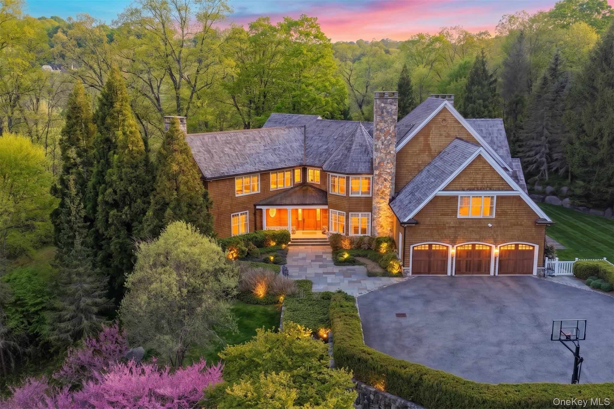 Set within the prestigious Thomas Wright Estates of Armonk, this extraordinary estate blends timeless architecture, exceptional craftsmanship, and sophisticated modern luxury. Privately perched atop beautifully landscaped grounds, the property offers remarkable privacy and tranquility just moments from downtown Armonk and an easy commute to New York City. A picturesque entrance framed by stately stone pillars introduces a residence thoughtfully designed with impeccable attention to detail, refined finishes, and elevated design throughout. Created for both luxurious everyday living and exceptional entertaining, the outdoor spaces feel like a private resort. A covered patio with a stone wood-burning fireplace overlooks the stunning gunite pool, hot tub, outdoor kitchen area, and beautifully designed pool house cabana complete with laundry, a full bath, indoor shower, and outdoor shower. A pristine level lawn provides the perfect setting for outdoor play and gatherings, while the basketball courtyard further enhances the home’s incredible lifestyle appeal. Extraordinary landscaping, architectural exterior lighting, and a cedar wood roof elevate the property’s striking presence.Inside, the sunlit interiors evoke the sophistication of an Architectural Digest showcase, featuring refined designer finishes, soaring 10-foot ceilings, quarter-sawn oak floors, custom millwork, cashmere wall coverings, and five fireplaces throughout. The stunning custom Deane chef’s kitchen is both elegant and functional, appointed with Calacatta Gold marble countertops, Barber Wilson’s London and Waterworks fixtures, Wolf and Sub Zero appliances, and a fully outfitted butler’s pantry with wine refrigeration and an additional entertaining dishwasher. Primary suite offers a true retreat with its own fireplace and spa-inspired bath that brings a sense of quiet luxury to daily life and all other bedrooms are ensuite, offering exceptional privacy and comfort.Designed with both elegance and lifestyle in mind, the home also features a sophisticated media room, billiard room, and an expansive walk-out lower level with a state-of-the-art gym and recreation area. A Crestron home automation system seamlessly integrates modern convenience into this thoughtfully curated residence where no detail has been spared. 16 Wrights Mill Road represents a rare opportunity to own an exceptional estate in one of Armonk’s most sought after neighborhoods where timeless luxury, comfort, and extraordinary craftsmanship come together beautifully and everyday living feels elevated.