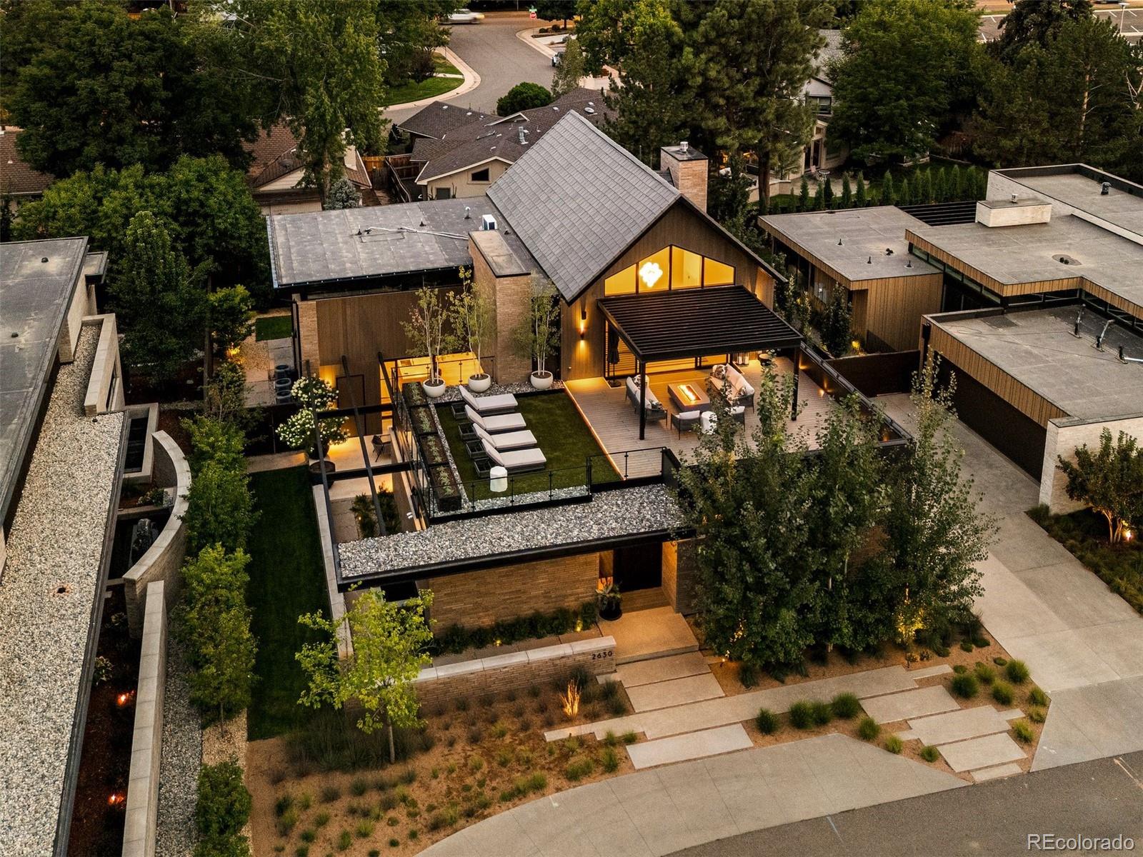 A rare opportunity awaits within an exclusive gated enclave of just eight homes, a stone’s throw from Cherry Creek North and the highly anticipated Cherry Creek West. This extraordinary residence spans over 7,000 square feet and blends architectural sophistication with thoughtful functionality. Anchored by a dramatic 12-foot custom oak pivot door, the home reveals a flowing floor plan designed for both grand entertaining and everyday living. The main level centers around a chef-inspired kitchen, complemented by a spacious prep kitchen offering dual dishwashers, wine refrigeration, abundant storage, and a seamless connection to the dining and great rooms. Multiple bars, including a custom 1,500 bottle wine cellar, a full lower-level bar, and an upper-level wet bar, elevate entertaining. Outdoor living rivals a five-star resort with three distinct spaces: an inner courtyard with a cozy gas firepit, a private backyard with a fully equipped outdoor kitchen, and a rooftop deck with pergola and gas firepit framing sweeping city and mountain views. Mature landscaping enhances privacy and creates a serene retreat in every direction.The primary suite is a sanctuary with a custom-built closet, cabinetry, and spa-inspired bath. Additional features include a home gym, elevator, dual laundry areas, and a heated 3-car garage with dog wash and full-size refrigerator/freezer. Smart-home technology integrates seamlessly throughout. Residents enjoy the security and convenience of a professionally managed HOA ($7,800 annually), which covers gate maintenance, private trash pickup at the home, snow removal (including sidewalks and paths), and upkeep of shared roads and fencing. This rare offering combines luxury, privacy, and lifestyle in one of Denver’s most coveted addresses.