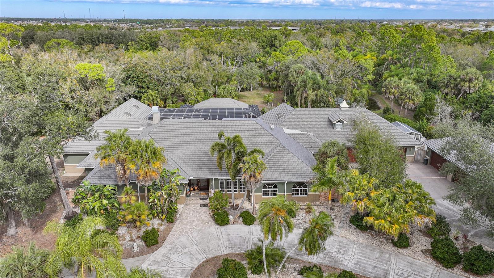 A Rare Hidden Estate of Unmatched Scale, Privacy, and PresenceTucked quietly behind the rhythm of everyday life, yet moments from the heart of Port Charlotte and Punta Gorda, 24646 Tangerine Avenue is a world entirely its own. This extraordinary country estate delivers over 8,000 square feet of refined interior living, blending grand architecture, resort-level amenities, and total seclusion into a singular offering seldom found in Southwest Florida.Beyond the gated entrance lies a property designed for those who demand both privacy and prominence. With six expansive bedrooms, four and a half baths, and an unrivaled 10-car garage capacity, this residence is as functional as it is impressive. A 2,400-square-foot BONUS building, attached AND detached garages with air conditioning opens the door to endless possibilities—collector storage, workshop, studio, or climate-controlled showroom.The estate unfolds as a private retreat, curated for relaxation and large-scale entertaining alike. At its center, a 36’ x 18’ resort-style pool anchors an expansive outdoor living environment, complete with a dedicated pool cabana for guests and gatherings. For the ultimate owner’s escape, a separate 14’ x 22’ enclosed pool sits just off the primary suite, creating an intimate, spa-like sanctuary reserved for quiet moments and restorative living.Natural beauty is woven seamlessly into the experience. A private pond spans the rear of the property, providing serene water views, a sense of depth, and a backdrop that feels worlds away from civilization—yet remains incredibly close to dining, boating, shopping, and beaches.Every inch of this estate speaks to scale, intention, and versatility. Whether envisioned as a multigenerational residence, private compound, luxury retreat, or legacy property, this is a home that adapts effortlessly to elevated lifestyles.Rarely does a property offer this level of square footage, acreage, privacy, garage capacity, and resort amenities—especially in such a central location.24646 Tangerine Avenue is not simply a home; it is an estate designed to be experienced, remembered, and passed down.