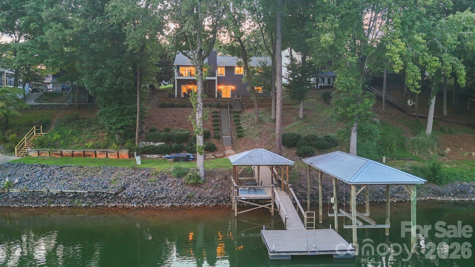 Welcome to lakefront living in Tega Cay, where the views, lifestyle and move in ready condition come together in one exceptional Lake Wylie home. From the moment you open the front door, natural light fills the home and draws your eye straight to the water.Unlike many waterfront homes that require extensive updating after you move in, this home is ready to enjoy from day one. The open main level was designed for entertaining, seamlessly connecting the kitchen, dining area and great room while keeping the lake views front and center. A beautiful fireplace anchors the great room and creates a warm gathering space just off the kitchen. The spacious kitchen features a large island perfect for entertaining, while expansive glass doors bring in tons of natural light and lead directly to more than 250 square feet of deck space overlooking Lake Wylie.The primary suite is located on the main level and features a beautiful walk in closet and upgraded bath with a large tiled shower and wall niche. An additional bedroom and full bath on the main level provide plenty of flexibility for family or guests. Thoughtful trim and ceiling details throughout the home give it character and make it stand out.The walkout lower level is made for lake life and entertaining, with stained concrete floors, a large recreation room with a second fireplace, two additional bedrooms, a full bath and a secondary kitchen and wet bar complete with an ice maker. Step outside to more than 900 square feet of brick paver patio space, giving you an incredible place to entertain, relax and enjoy the lake.Head down to your private covered dock, complete with a 10,000 pound boat lift and 40 amp electrical service. The dock also features a covered sitting area with a ceiling fan, giving you a shaded place to relax right by the water.Start your morning with coffee overlooking Lake Wylie, spend the afternoon on the boat and come home to relax with a glass of wine as the sun goes down. This home gives you the lake lifestyle without sacrificing the comfort and finishes you want inside.With multiple outdoor entertaining spaces, beautiful waterfront views, tons of natural light and a new roof installed within the last 12 months, this is an opportunity to enjoy everything Tega Cay and Lake Wylie have to offer without taking on a major renovation after closing.Move in, get the boat on the water and start enjoying Lake Wylie.