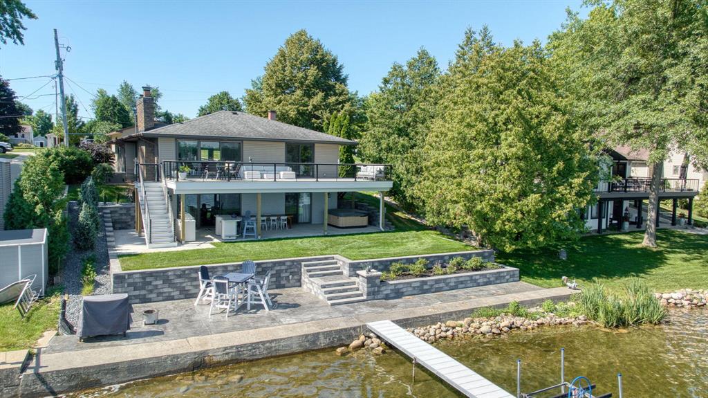 Welcome to a very rare opportunity on highly sought-after Clark Lake! This beautifully updated lakefront property offers the perfect blend of charm, comfort, and convenience with 64 feet of private, pristine lake frontage. Recent improvements include a brand new expansive deck overlooking the lake (2024), below-deck patio with an under-deck gutter system making it enjoyable rain or shine (2024), beautiful lakeside patio perfect for lounging by the water (2024), garage doors (2023), fresh landscaping, new lawn irrigation and sprinkler system, fresh interior paint, iron trap (2024), and much more!Inside, you'll find 3 bedrooms and 3 full baths. The first level features a large and open living area leading out to the deck, a primary suite with a private sliding door to the deck, as well as the second bedroom, the second full bathroom, and the main kitchen. Downstairs includes a finished walkout basement with a second kitchen, spacious living area with a slider out to the below-deck patio, the third full bath, and the third bedroom with its own slider to the patio - ideal for guests and seamless lakefront enjoyment. This home comes equipped with a whole-house generator, ensuring uninterrupted comfort and peace of mind during power outages.

What truly sets this home apart is the incredibly rare bonus: of the 0.61 acres, 0.30 of that resides directly across the street. This bonus area features a large pole barn - perfect for boat storage, lake toys, or future possibilities. Very few homes on Clark Lake offer this kind of added space and flexibility!

With three garage spaces total - an attached one-car and a detached oversized two-car garage - you'll have room for everything! Located on the scenic 7.3-mile Spirit Trail, this home offers direct access to walking, running, and biking right outside your door. Clark Lake is a four-season playground with year-round events and two popular restaurants you can boat right up to and dine. Don't miss this one-of-a-kind chance to own a slice of Clark Lake with room to grow!