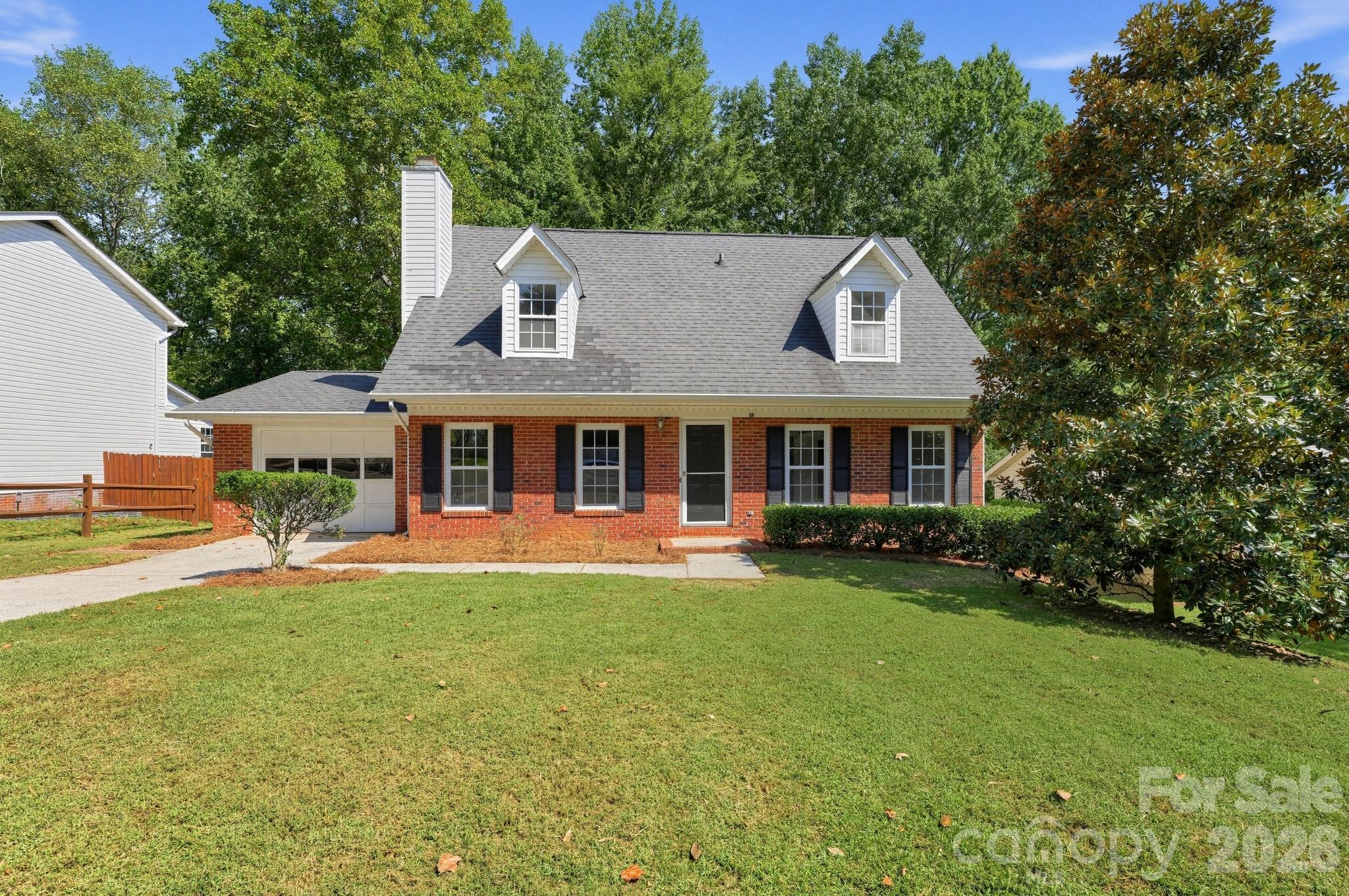 Charming brick 1.5-story colonial featuring classic dormer windows and a spacious driveway. Inside the living room offers a cozy fireplace and into a bright, white-cabinet kitchen. Main-level primary suite with walk-in closet, plus 2 additional bedrooms and 2 full baths. Enjoy the private, wooded backyard from the rear deck.