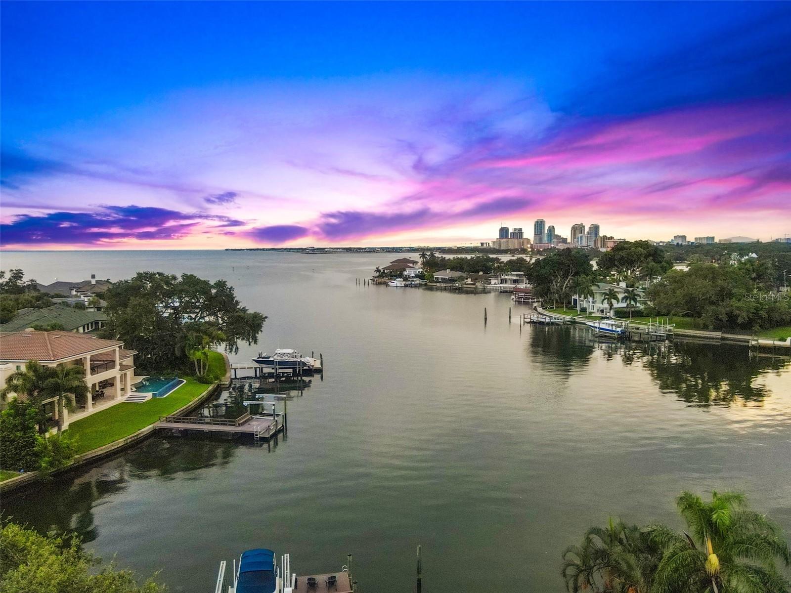 Breathtaking Waterfront Living on Iconic Brightwaters Blvd NE in Snell Isle!! 1365 Brightwaters Blvd is located on one of the most coveted blocks in St. Petersburg, this exceptional residence offers unobstructed views of downtown and the St. Pete Pier and sits on deep, protected sailboat water—ideal for boaters and water lovers alike. A striking modern design, this home has been completely redesigned to showcase a bright, open layout with multi-level living and expansive views from nearly every room. The main living area features soaring 14-foot ceilings and an open-concept great room perfect for entertaining. At the heart of the home, the designer kitchen is equipped with top-of-the-line appliances, an oversized island with bar seating, and a sleek butler’s pantry offering extensive storage, laundry facilities, and elevator access. A custom, temperature-controlled glass wine room adds an elegant and luxurious touch, while a private home office offers a quiet space to work or study. The lower level offers a versatile guest suite with its own living and dining space, a full bath, plus an additional guest bedroom with an en suite. A wet bar connects this level to the expansive outdoor entertainment area, ideal for hosting guests, providing in-law accommodations, or creating a private retreat for college-age children or a nanny. The primary suite is thoughtfully positioned on its own level for maximum privacy and features stunning water views from its private balcony. The en suite bathroom is a spa-like haven, with floating soaking tub, dual vanities, a glass-enclosed shower, and bespoke designer finishes. The walk-in closet has been fully customized with built-ins and a central lingerie island.Step outside to your ultimate outdoor sanctuary—whether you're sunbathing on the upper deck, sipping your morning coffee while watching dolphins play, or entertaining poolside in the covered, climate-conscious swimming area. The dock is equipped with a 10,000 lb boat lift, making it easy to explore downtown St. Pete by water in under 10 minutes or venture to Tampa Bay and the Gulf beaches within a half hour.This location is truly unmatched—just minutes from vibrant downtown St. Petersburg, where you can walk, bike, or golf cart to waterfront parks, award-winning restaurants, charming cafés, world-class museums, galleries, and the historic Vinoy Resort and Golf Club. Experience luxury living in one of the most sought-after waterfront neighborhoods in Tampa Bay—Snell Isle.