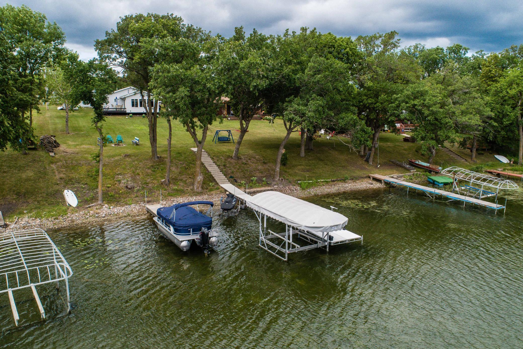 EAST LOST LAKE - MOVE-IN ready!  Don’t miss the chance to experience lake living in this adorable 2 bedroom, 1 bath year-round home with 80 feet of hard sand shoreline, conveniently nestled in the heart of lakes country near Ottertail and Battle Lake.  Features include one level living, knotty pine interior, open floor plan, kitchen island, 4 season lakeside sunroom/living area, free standing gas fireplace, lakeside firepit, detached single garage, and an 8 x 8 storage shed.  Property comes fully furnished with beds, bedding, couches, table and chairs, adorable lake decor, cookware, outdoor furniture, and a dock.  Recent updates include blinds in living room, bathroom and kitchen, new mini-split heating/AC unit, freshly stained deck, freshly painted outdoor swing and firepit furniture, removal/trimming of many trees, and several new perennial plants, enhancing comfort and aesthetics.  East Lost Lake is over 483 acres with a maximum depth of 36 feet with all types of water recreation.
