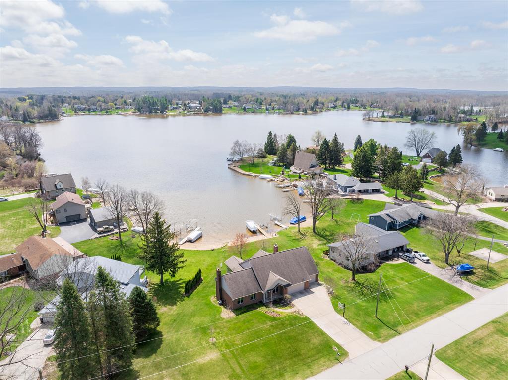 Lakefront living shines in this ranch on a prime stretch of Lake Lapeer, offering unobstructed main bay views and a walk-in sand beach. The full walkout lower level with a second kitchen makes entertaining easy, while oak hardwood floors and the sunroom addition add warmth and character to the main level. Built with 2x6 construction and reconstructed in 1994, this home was designed for both comfort and function. The main garage was completely rebuilt in 2019 with epoxy floors and drain, and the lakeside fourth garage is perfect for boat and water toy storage. Space beneath the garage adds even more versatility for a theater room, recreation room, or hobby space. Whether enjoying quiet mornings by the water or hosting long summer weekends, this property captures the best of lakefront living with a rare waterfront position, thoughtful features, and an easy connection to the outdoors.