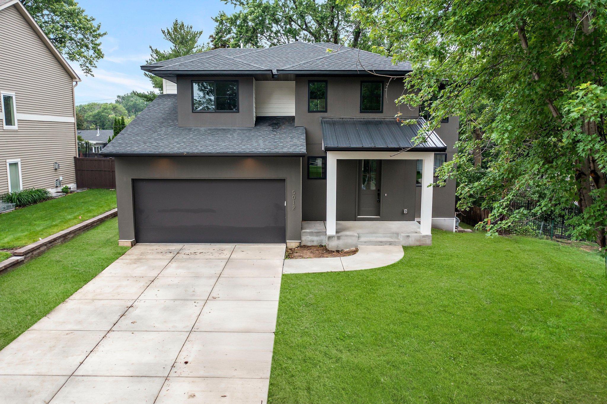 Introducing a newly constructed 5-bedroom, 5-bathroom Stone Cottage home in the heart of one of Edina’s desirable neighborhoods, located within the sought-after Edina School District. This elegant residence is ideally positioned near three renowned golf courses, several scenic parks, premier shopping and dining options, and is just a short drive to the shores of Lake Harriet. From the moment you step inside, you're welcomed into a grand foyer with soaring 19-foot ceilings and a striking chandelier that sets the tone for the rest of the home. Just off the entryway, a hall closet and convenient half bathroom offer added functionality. A versatile den near the front of the home features pocket doors, a closet for extra organization, and a large window overlooking the front yard—ideal for a home office, study, or additional living space. The kitchen is a showstopper, designed with entertaining and everyday living in mind. It features double wall ovens, a gas cooktop, matte black Café appliances, a spacious center island with storage and breakfast bar seating, elegant tile backsplash, stylish two-tone cabinetry with under-cabinet lighting, and a walk-through pantry measuring 8 by 5 feet. The open concept flows seamlessly into a sun-filled dining area with large picture windows, statement lighting, and direct access to the backyard patio—creating the perfect space for indoor-outdoor entertaining. The living room is both cozy and sophisticated, anchored by durable wood flooring, expansive windows, and a sleek, remote-controlled gas fireplace with modern tile surround. Every detail has been thoughtfully considered for comfort and design. Upstairs, the primary bedroom is a private retreat, entered through elegant French doors and filled with natural light from oversized windows. The room features plush carpeting and a spacious 17 by 7 walk-in closet with custom shelving. The private en suite bathroom is designed for relaxation with a tiled walk-in shower, a deep soaking tub, two separate vanities, beautiful tile flooring, and a linen closet for added storage. Two additional bedrooms on the upper level are spacious and filled with natural light. They are connected by a split-designed Jack and Jill bathroom, featuring a double vanity and a combination tub/shower with tile surround. Across the hall, a fourth bedroom includes cohesive carpeting, built-in wall shelving, and a 5 by 6 walk-in closet. It is also connected to its own ¾ bathroom with a tile walk-in shower and single vanity. A conveniently located laundry room with front-loading washer and dryer, sink, cabinetry, and counter space completes the upper level. The lower level is perfect for recreation or relaxation, featuring a spacious 24 by 14 family room with LVP flooring and recessed lighting, ideal for hosting gatherings or enjoying movie nights. A stylish wet bar includes wood shelving, a tile backsplash, refrigerator, and sink, making it a great entertaining hub. A fifth bedroom on this level is finished with cozy carpeting and windows for natural light. It connects to a walk-through ¾ bath with tile walk-in shower, single vanity, and linen cabinet—perfect for guests or family. Functional and stylish, the mudroom offers cabinetry, counter space, a bench for seating, a 5 by 5 closet, and direct access to the attached garage. The three-car garage includes a remote-opened door and a tandem stall extending 43 feet—ideal for extra vehicles, recreational equipment, or workshop space. The exterior is just as inviting, featuring a 15 by 8 front porch where you can enjoy peaceful sunrises, and a backyard patio surrounded by mature trees and tranquil neighborhood views.