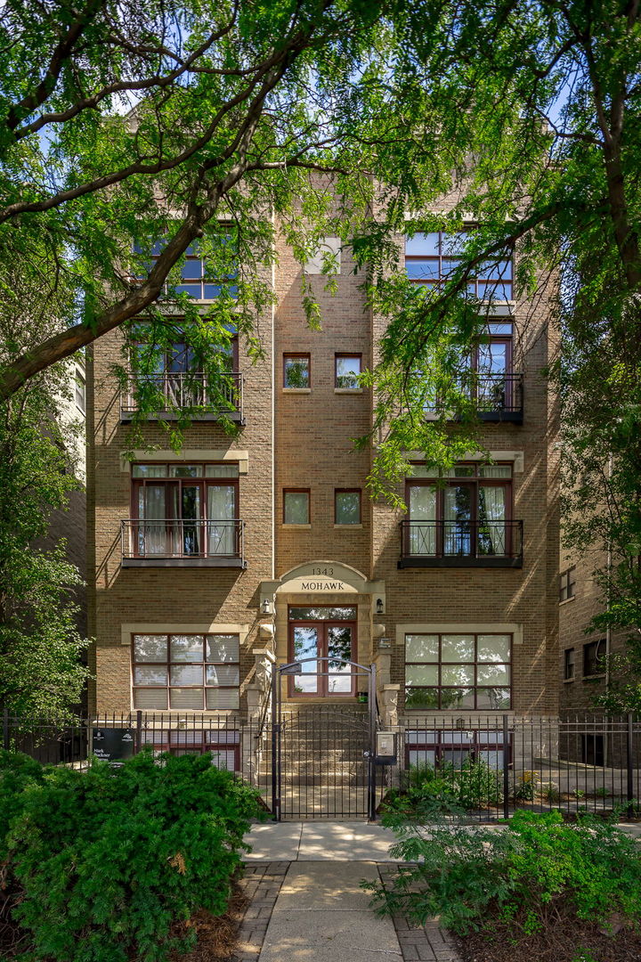 Experience luxury city living in this stunning 3-bedroom, 3-bath penthouse duplex with sweeping skyline views. A dramatic cathedral ceiling soars above the open living and dining area, while a wall of windows floods the space with natural light. Gleaming oak hardwood floors run throughout, leading to an open-concept kitchen with granite countertops, stainless steel appliances, a center island, and freshly resurfaced wood cabinets. The main level features two spacious bedrooms. One offers an en suite bath and access to a charming wood balcony. The second, currently used as an office, includes a custom built-in cabinet that conceals a hidden room-ideal for storage, a personal bar, or a butler's pantry. Upstairs, the private primary suite boasts an en suite bath with a double vanity and direct access to a Trex rooftop balcony-perfect for entertaining, taking in the skyline, or watching the sunrise over the lake. A family room overlooking the double-height living space enhances the open, airy feel. One garage parking space is included. Located in the heart of Old Town, this home offers easy access to vibrant Wells Street while feeling tucked away on a mature, tree-lined street. Enjoy boutique shops, coffee spots, restaurants, and nightlife just steps from your door, with the lakefront, Lincoln Park, and public transit close by.