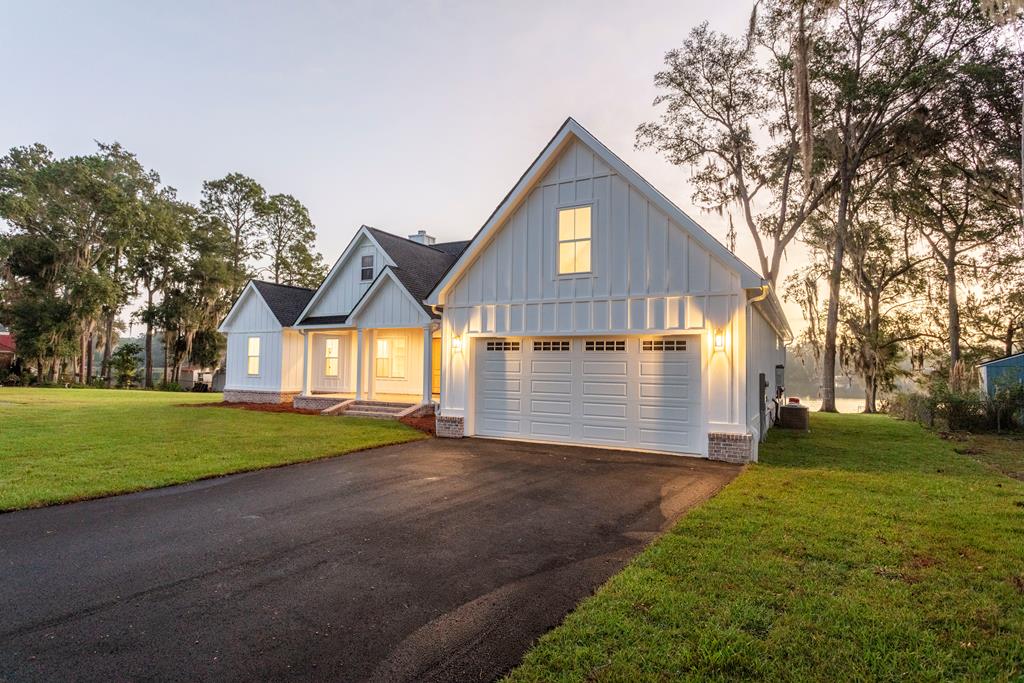 Breath taking new custom home - Lake front! This spectacular new, 2,461 Sq Ft 4 bedroom, 4 .5 home is like your own personal resort! Custom built with too many upgrades to list, perched on the banks of glistening Lake Riverside, just minutes from historic downtown Thomasville. Enormous fireside great room is open and drenched with sunlight and overlooks lake. Custom features include towering cathedral ceilings, two story brick fireplace with beamed accent and mantel board. Large open family kitchen and dining room, kitchen with custom cabinets and 3/8 bevel calacatta quartz counter tops, stainless steel appliances including, gas range with built in air fryer tray, pot filler, french door refrigerator with craft ice dispenser, smart wifi enabled dishwasher, Kohler Studio McGee faucets, fixtures and  cabinet hardware, walk in pantry with icemaker connection and bountiful cabinetry, Separate laundry room with sink is adjacent to oversized two car garage. Each bedroom, features on-suite bath, 3 of the 4 bedrooms are on the main level, one is on second level for added privacy, and could even be used as a home theater or in-law suite. Main level primary suite is pre-wired for an electric fire place, and features luxury resort style bath and walk in closet. Custom interior finishes such as real pine craftsman doors, give a nod to the many rustic yet sophisticated features of this contemporary farm home. Outside, the .061-acre lot is professionally landscaped, and features an irrigation system that conserves water by using lake water to hydrate lawn! High end meachanics such as  water filtration system, tankless water heater. The home has a gutter system, a large deck with Trex flooring and a spectacular view of the lake. This home is one of a kind with unmatched quality and attention to detail and is ideal for your forever home retreat !