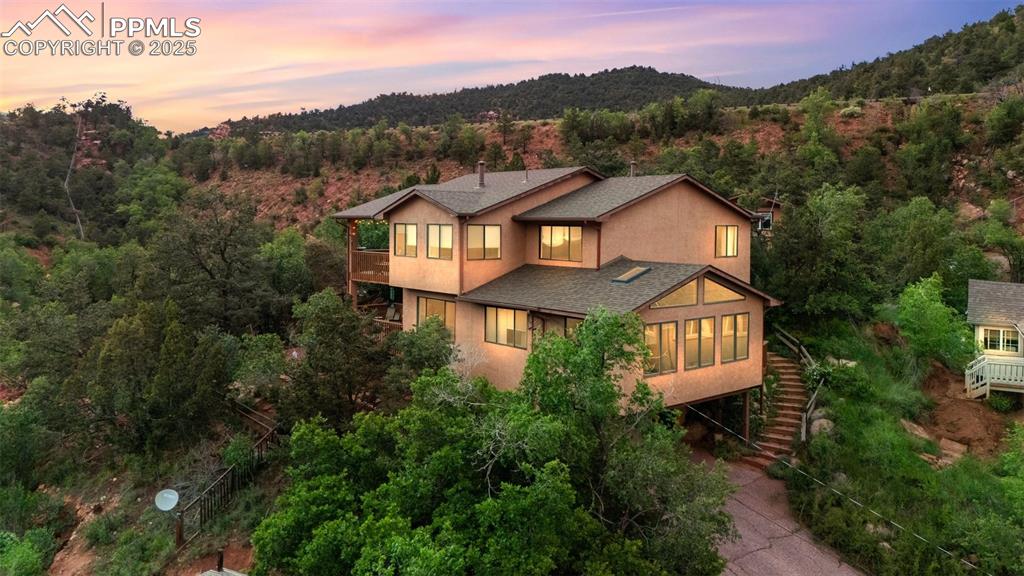 Located in sought-after Manitou Springs, this unique property boasts beautiful views of Pikes Peak and the foothills, red wood decks, oversized two-car garage with extra storage, two gas fireplaces and six-person cedar sauna. The home is comprised of 3 bedrooms, 2 1/2 ba, (over-sized jetted soaking tub in primary), dining room, living room, family room, kitchen opens to a spacious additional garden room area with two skylights and deck.
Home has an exquisite detached studio w/electricity nestled quaintly on this large lot.
With lovely gardens and a cozy, private vibe, decks off living room, bedroom and garden room and views in every direction this rare Manitou property is just a ten-minute walk to downtown Manitou Springs with many restaurants, shops and Historic Arcade.