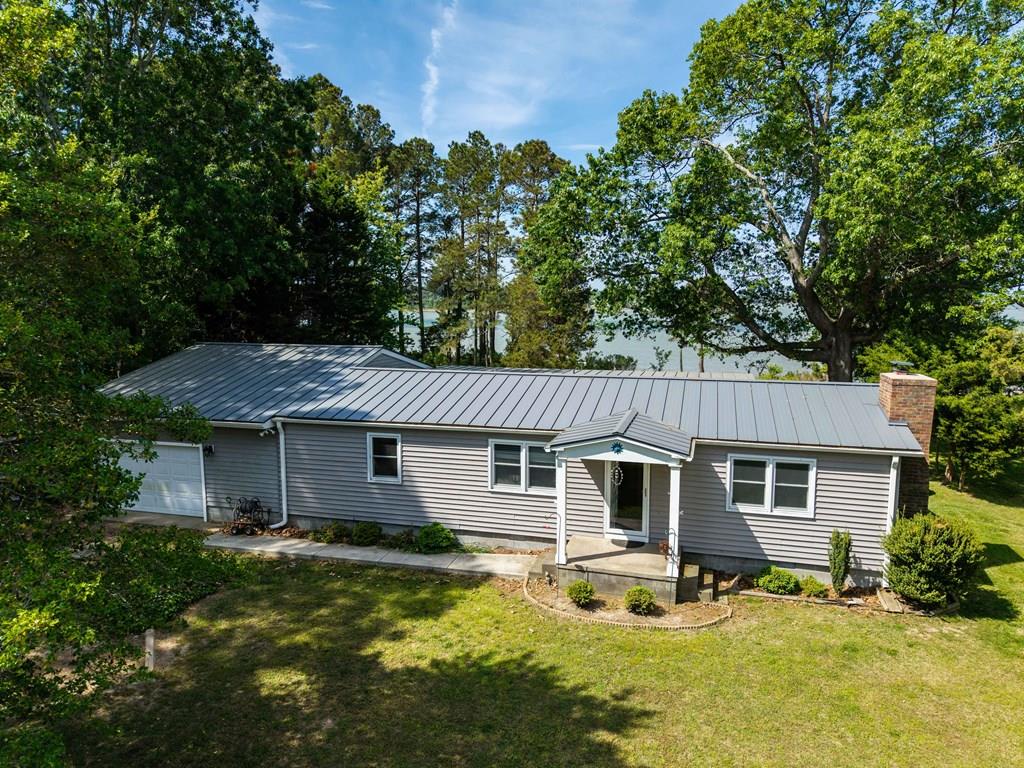 Don't miss this three-bedroom, two full bathroom ranch home on a beautiful waterfront lot just under a half-acre with beautiful views of Curratuck Creek and easy access out to the Chesapeake Bay. The spacious Florida room and enclosed back deck have incredible natural light and sprawling water views, and the attached two car tandem garage has plenty of space for extra storage or our very own workshop. Some upgrades and updates include a new Steel Roof 5 years ago, new vinyl siding 3 years ago, and new underground well, and the Primary bathroom was renovated 5 years ago with an electric tankless water heater. Come experience privacy and nature in this perfectly situated residence in Painter on the water, and all the Chesapeake Bay has to offer.