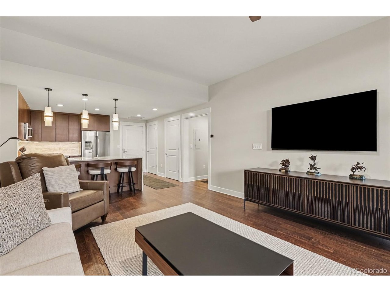 Welcome to 7220 W Bonfils Lane #206, a completely renovated 1-bedroom, 1-bath condo in the heart of Belmar, combining high-end finishes, exceptional outdoor living, and a truly move-in-ready lifestyle. Thoughtfully updated throughout, this residence offers a level of finish that sets it apart.The remodeled kitchen is the centerpiece of the home, featuring beautiful stone countertops and backsplash, a waterfall-edge island with seating, modern cabinetry, premium Bosch stainless steel appliances, a beverage refrigerator, under-cabinet lighting, and contemporary fixtures. The open-concept layout flows seamlessly into the bright living area, where large windows, wood flooring, and direct patio access create an inviting space for everyday living and entertaining.The spacious bedroom provides a comfortable retreat, while the completely remodeled, spa-inspired bathroom features a double vanity, illuminated mirror, frameless glass shower, separate soaking tub, custom tile and stonework, and contemporary fixtures.One of the home's standout features is the oversized private covered patio, extending the living space outdoors and offering mountain views. The unit also includes one parking space and a private storage unit in the underground garage.Located in the heart of Belmar in Lakewood, Colorado, restaurants, coffee shops, shopping, entertainment, grocery stores, plazas, and community events are just outside your door. Downtown Denver, the foothills, and major commuter routes are also within convenient reach.For buyers searching for a remodeled Belmar condo, luxury finishes, private outdoor space, underground parking, and a walkable Lakewood lifestyle, Unit #206 offers a combination that's difficult to duplicate. Completely renovated, beautifully finished, and ready to move in and enjoy.