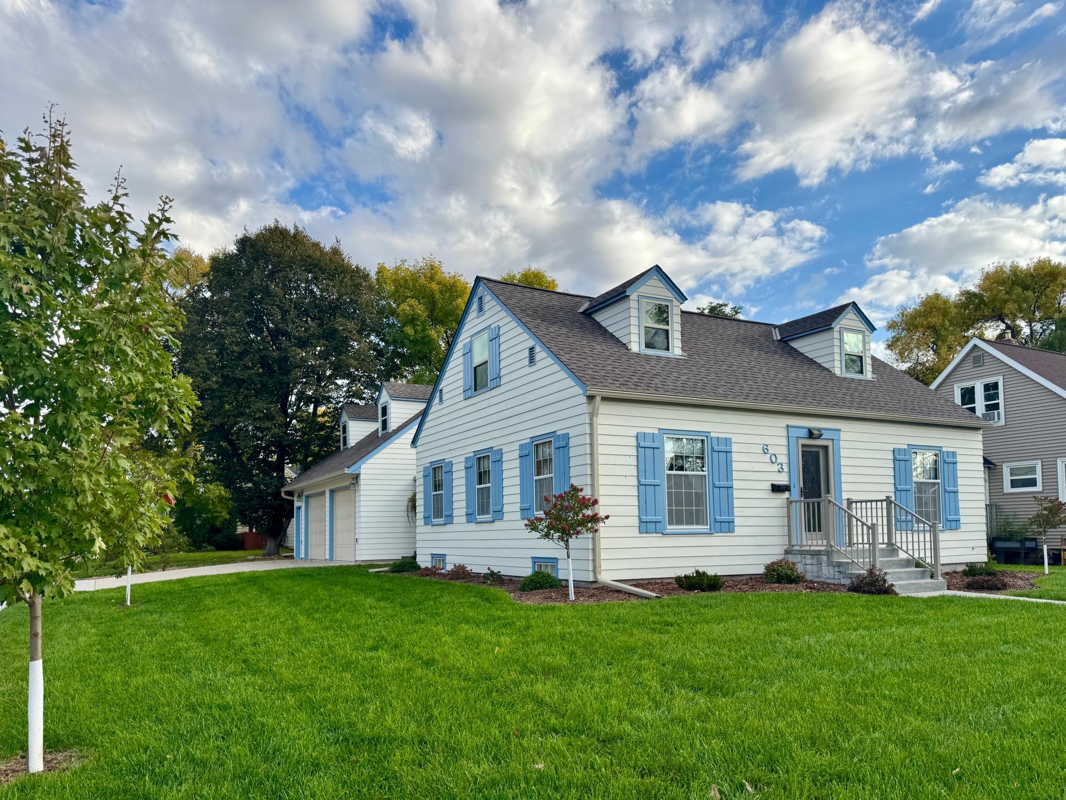 Welcome home to this beautifully maintained 1½-story Cape Cod–style home, filled with warmth, charm, and character! Situated on a spacious corner lot in a quiet neighborhood, this inviting property offers 4 bedrooms, 2 bathrooms, and a wonderful blend of comfort and functionality. The main level features two bedrooms, a updated bathroom with tile shower and stone top vanity, a cozy living room with an electric fireplace, and a dining area just off the kitchen. Enjoy additional living space in the bright sunroom, with patio door access to a beautiful paver stone patio—perfect for morning coffee, relaxing evenings, or entertaining guests. Upstairs, you’ll find two additional bedrooms, while the basement offers a spacious family room, second bathroom, and an additional storage room for added convenience. The attached 2+ stall garage is insulated and sheetrocked, providing a comfortable, finished space for vehicles, hobbies, or extra storage, along with potential for a bonus room above. Conveniently located within a close distance of downtown, dining otpions, the outdoor aquatic center, library, and elementary school. With its classic dormer windows, welcoming curb appeal, and beautifully maintained condition, this warm and inviting home is truly a must-see!l