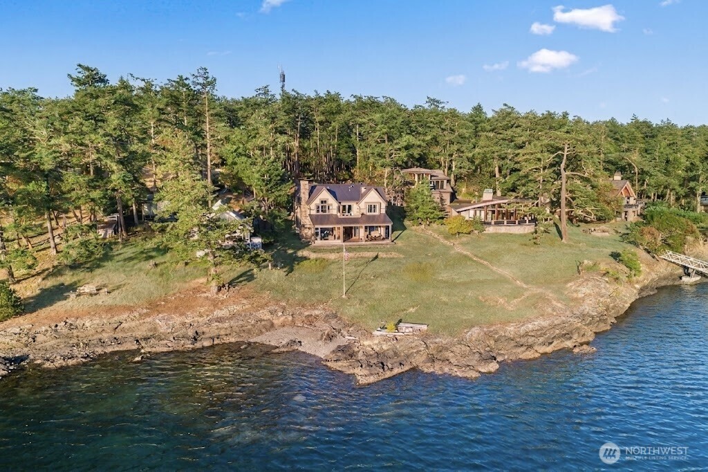 Experience the ultimate in coastal living in this stunning Craftsman-style home set on rare no-bank waterfront in the coveted community of Cape San Juan. This architectural masterpiece is beautifully crafted with timeless, high-end finishes throughout. Impeccably maintained, the residence feels brand new and offers an unparalleled standard of island luxury. Enjoy dramatic western exposure that provides a front-row seat to the Salish Sea’s most unforgettable sunsets each evening. The heart of the home is a gourmet chef’s kitchen that opens seamlessly to a heated, covered patio, creating a perfect environment for year-round dining and sophisticated entertaining. The thoughtful floor plan features two spacious primary suites, one on each level, to provide comfort and flexibility. Two additional bedrooms and den/office space are strategically placed within the home to ensure privacy. Unwind by the cozy fireplace or step outside to launch your kayak or paddleboard directly from your own pebbled beach. Enjoy the convenience of your own private mooring buoy for your boat. Offering a unique connection to nature where you can enjoy watching abundant wildlife. As part of the coveted Cape San Juan community, you will also have access to top-tier amenities including a seasonal swimming pool, a private marina, a sandy beach, and miles of expansive scenic walking trails. This is a rare waterfront retreat designed for creating a lifetime of memories in a setting of unmatched natural beauty.